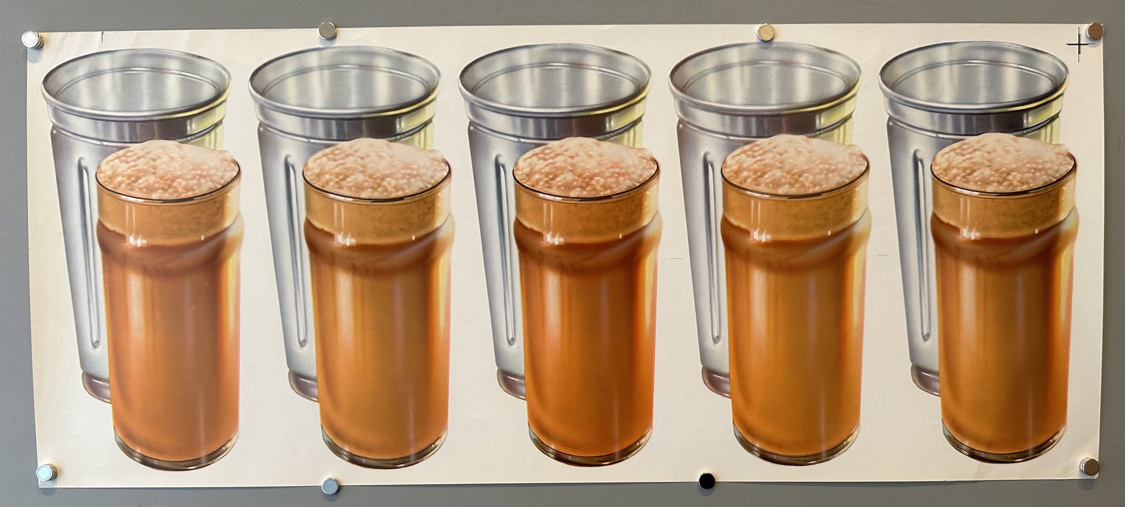 Beige background. This poster depicts five egg cream drinks lined up in a row, with metal cups behind them. The egg cream drinks are shown with a foamy top and a light brown color, and the metal cups are a shiny silver.