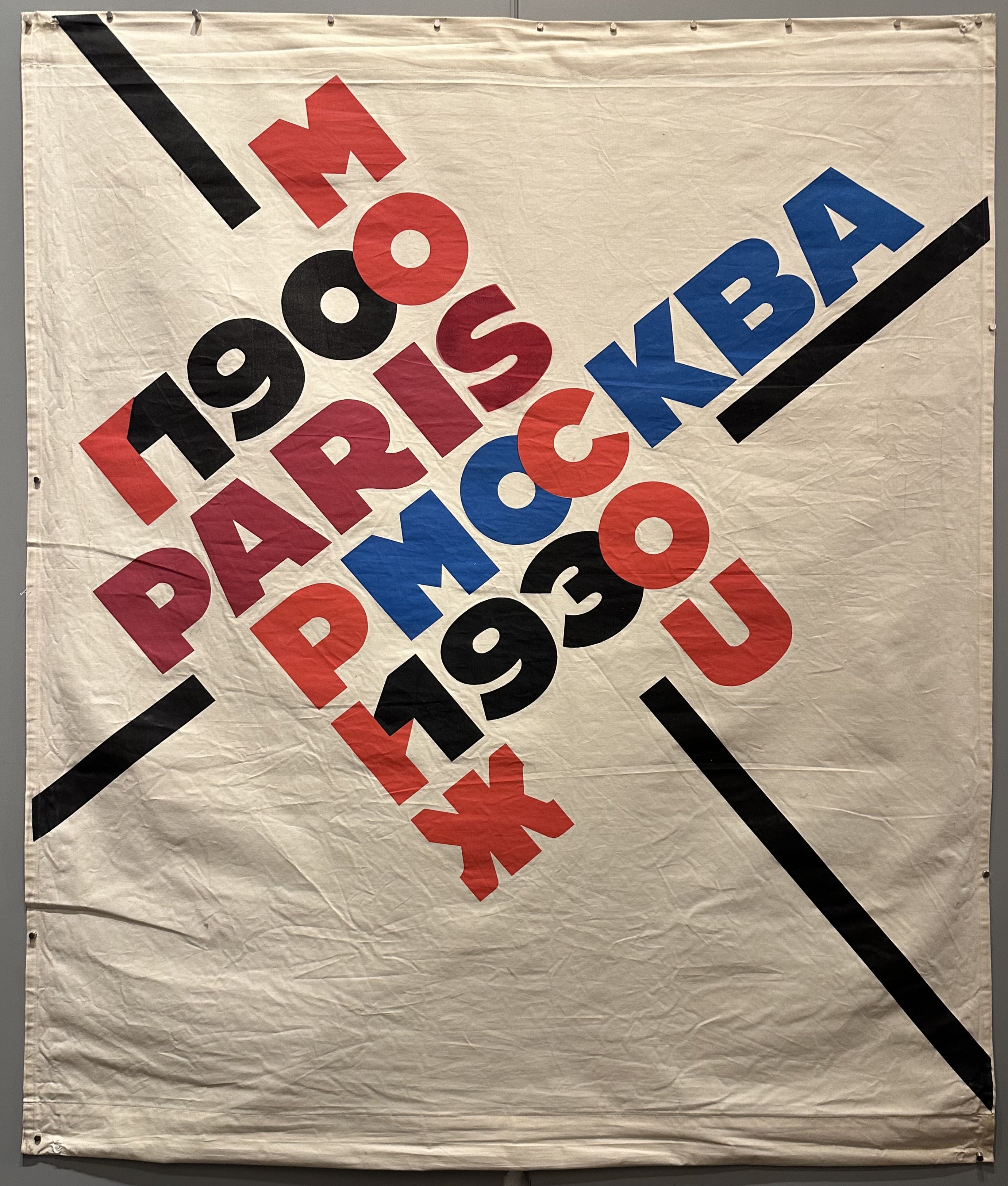 Cloth banner with an acrostic of Paris/Moscow written in their respective languages.