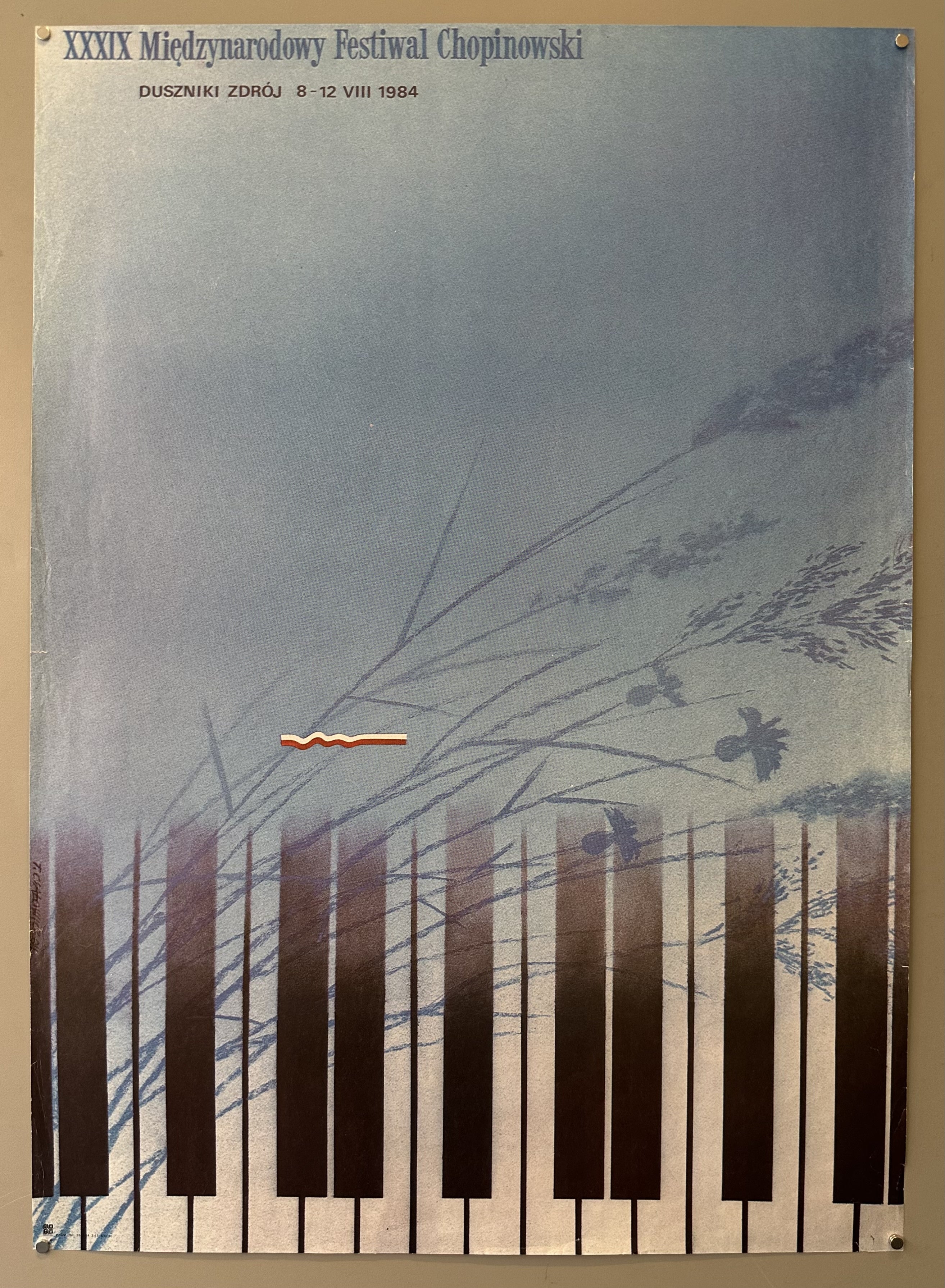 Blue poster with piano keys fading along the bottom edge to promote a classical music festival in Poland.