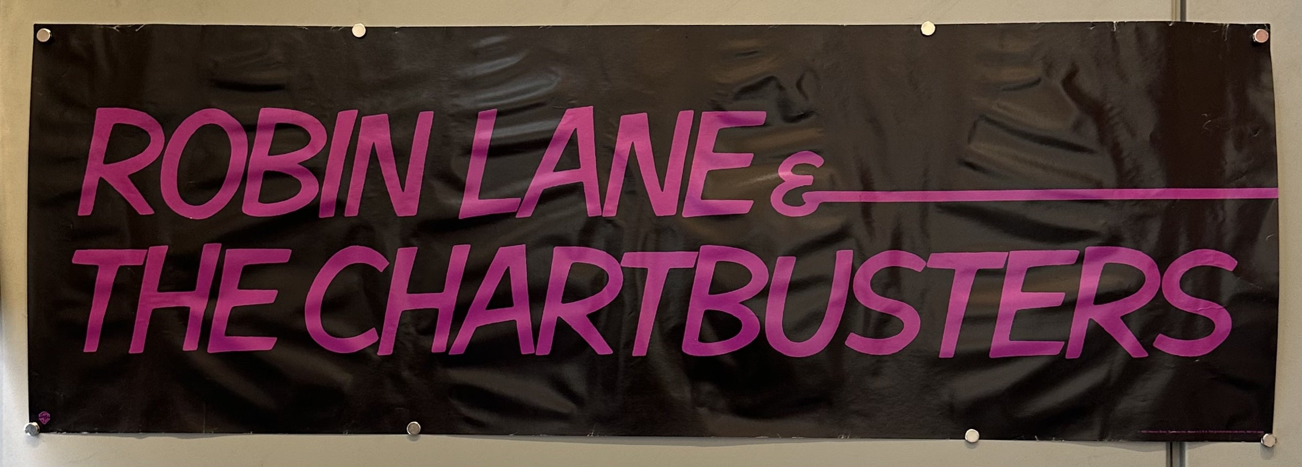 Black poster with purple text reading Robin Lane & The Chartbusters.