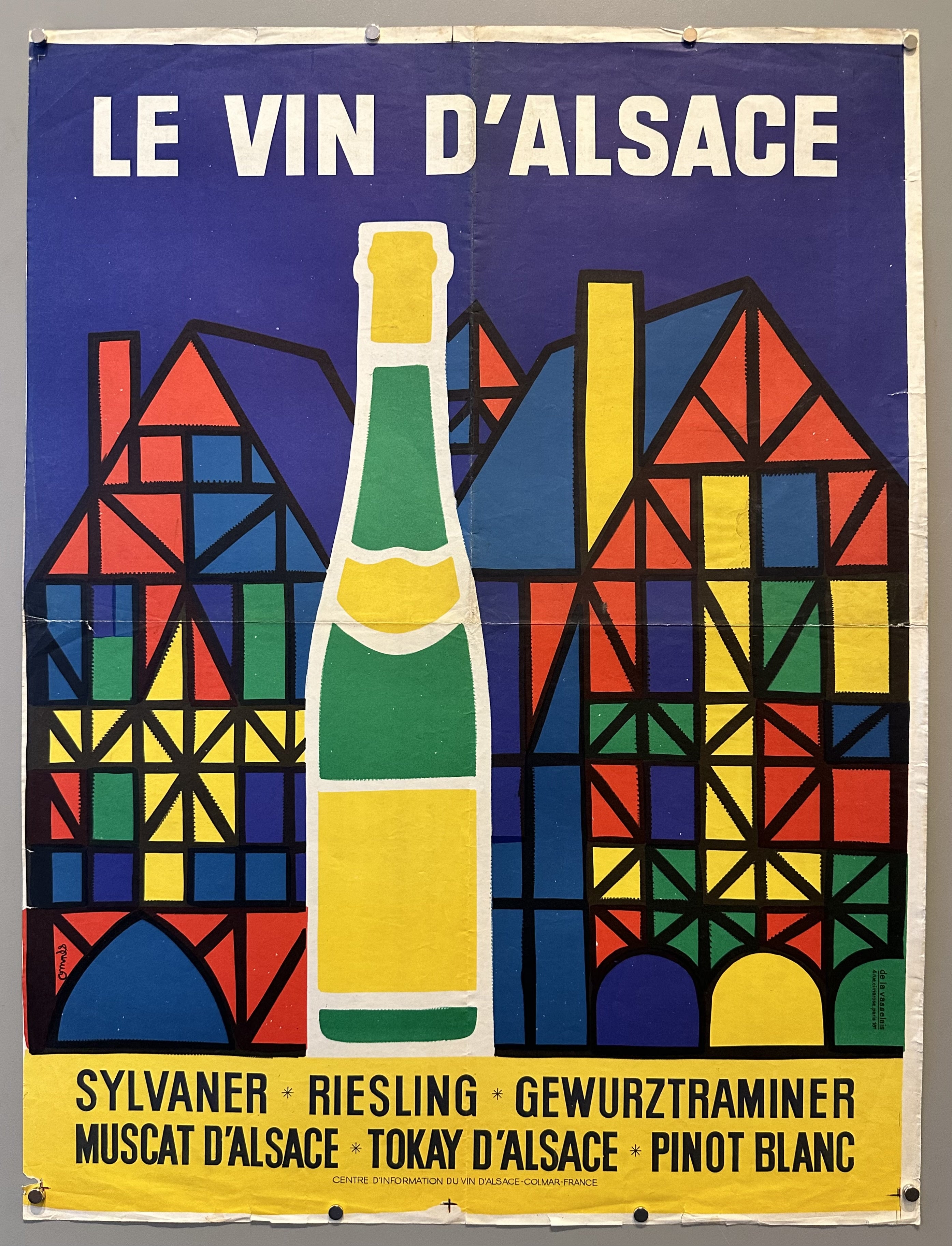 Wine bottle against mosaic style homes with wines listed below it.