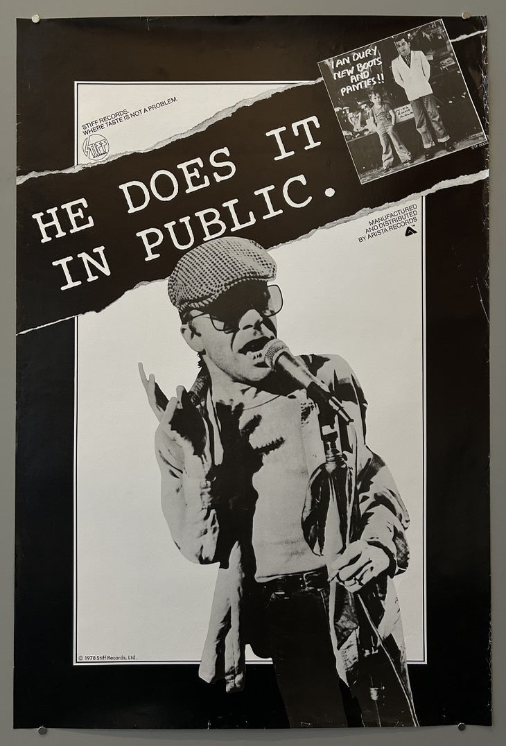 A vintage black and white promotional poster for Ian Dury's album "New Boots and Panties!!" features a central image of Ian Dury in a flat cap and glasses, holding a microphone and making a hand gesture, with the text "HE DOES IT IN PUBLIC.