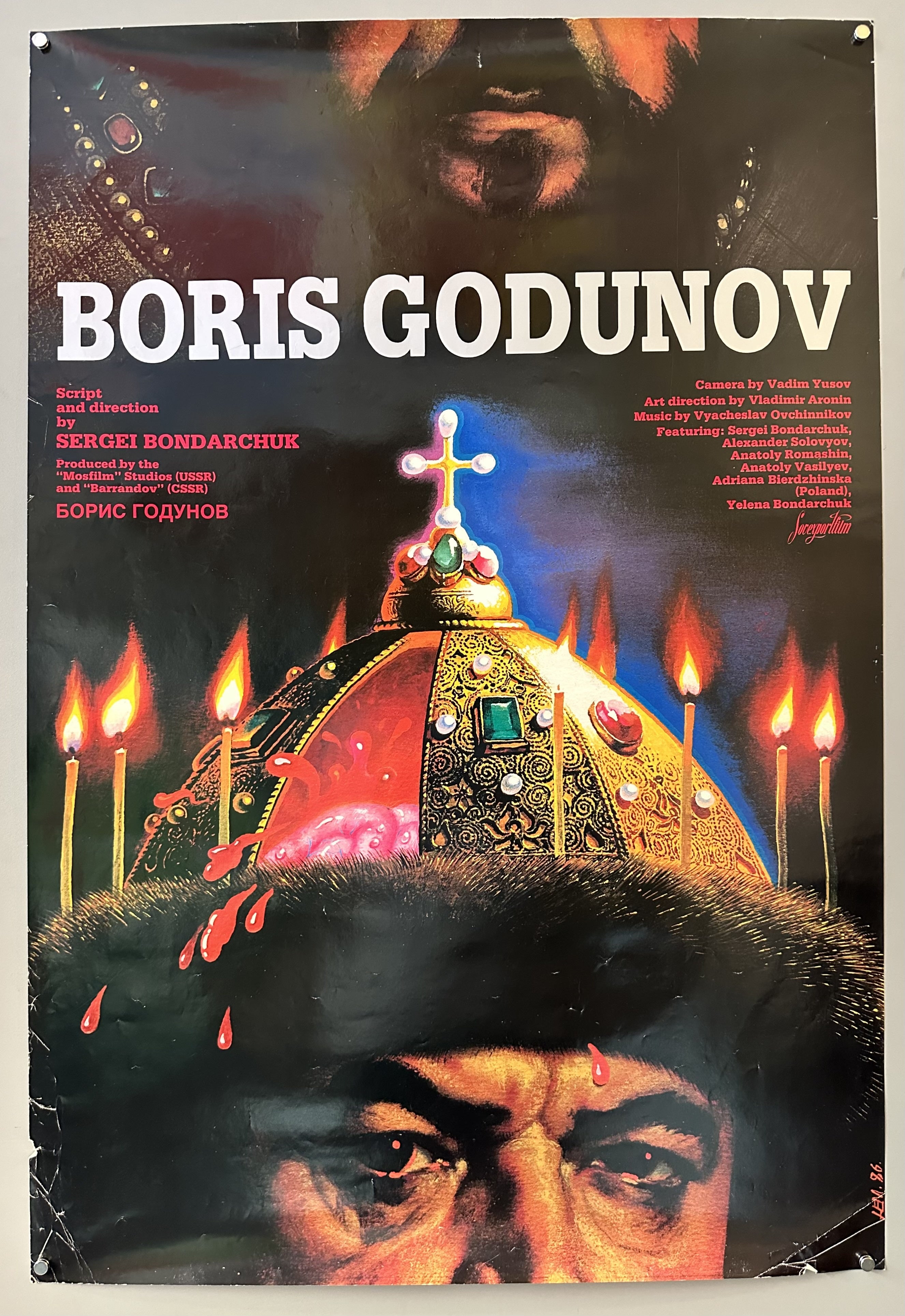 Boris Godunov is written in bold white font on the top with descriptions of who took part in the project on each side of the text. A mans face is split in half, he is wearing a cold cap with candles along the rim of it.