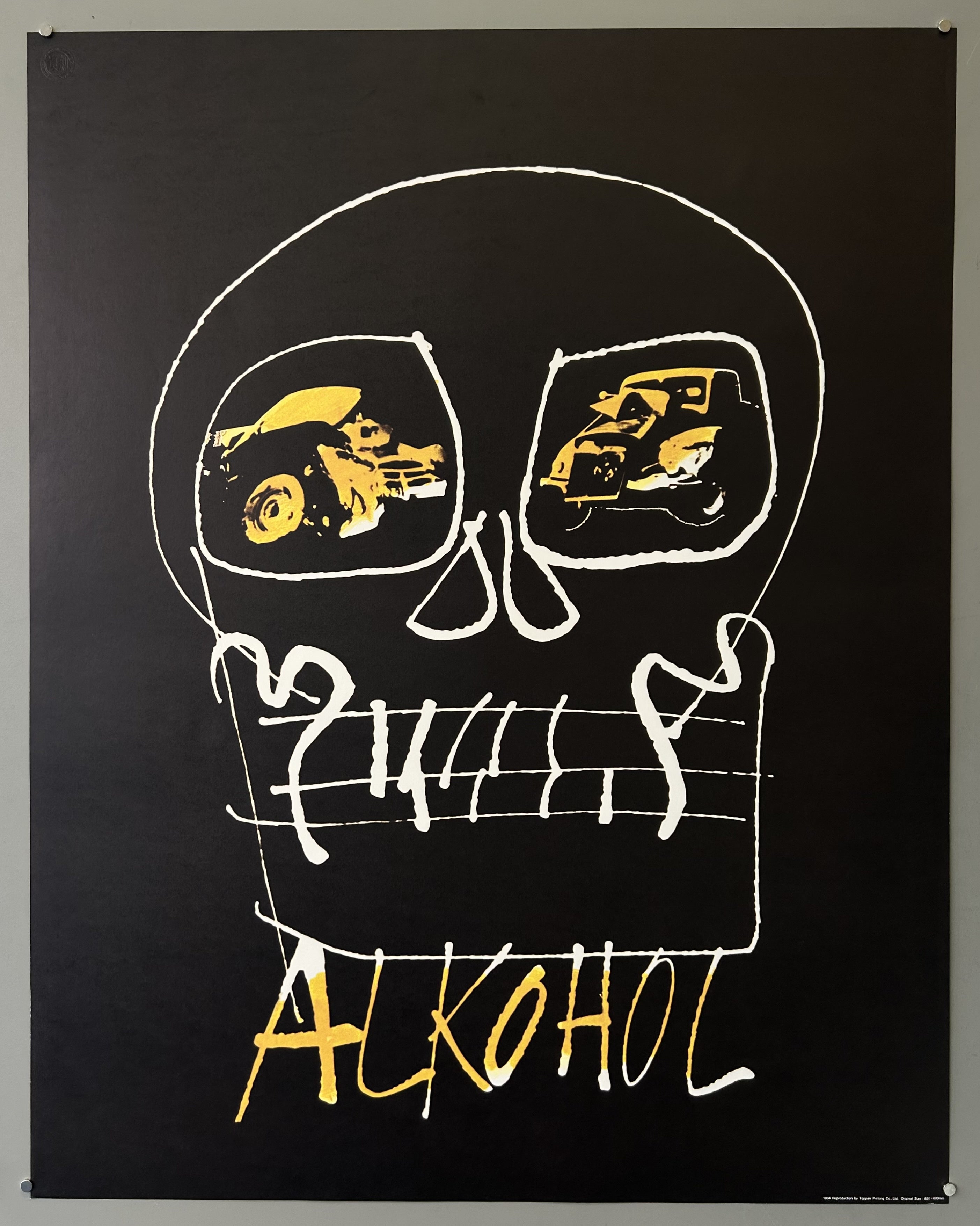 Poster places the auto wrecks in the eye sockets of the skull with hastily scrawled text in yellow along bottom.