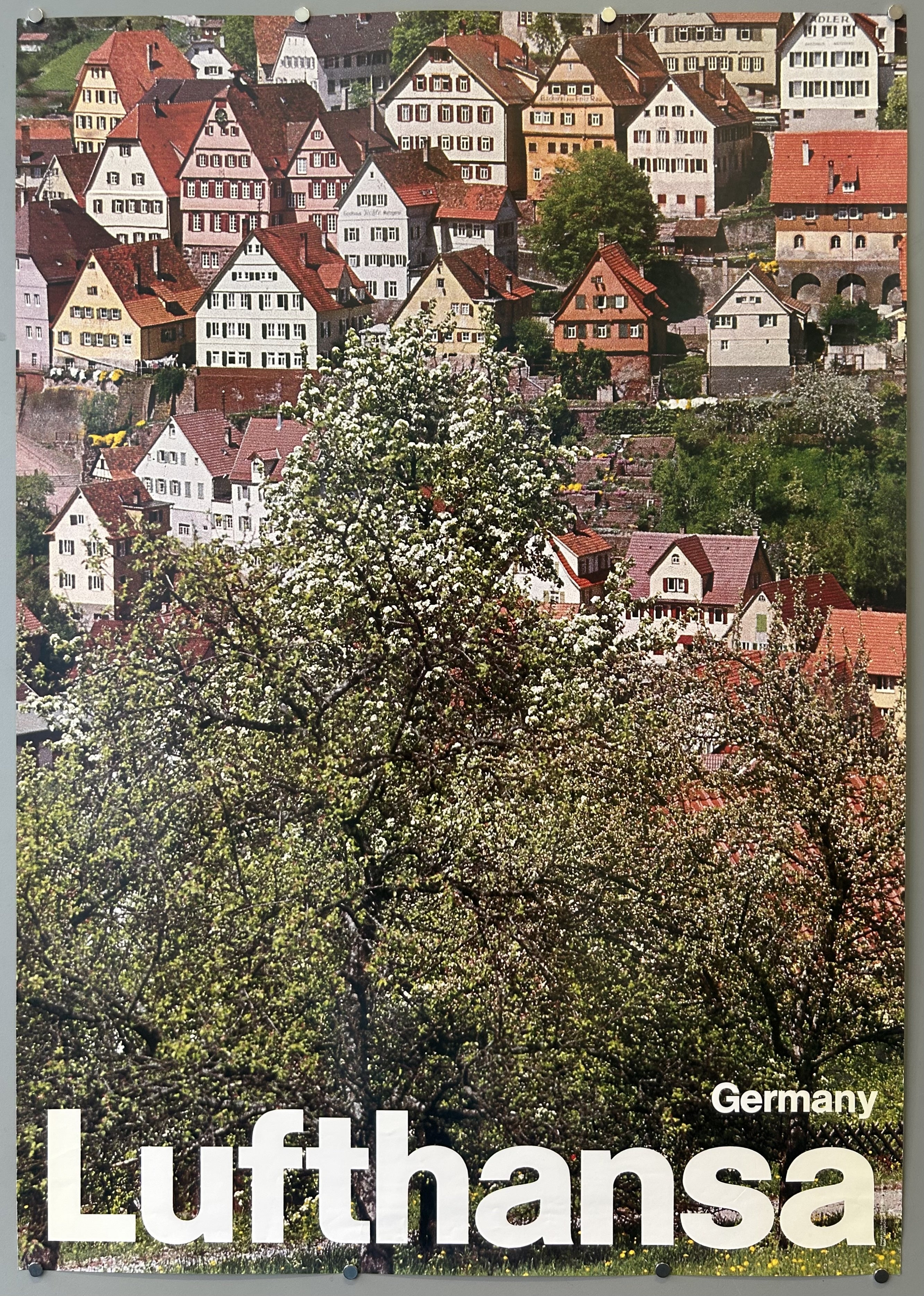 Photograph of German village in vintage travel poster from Lufthansa, text is located along bottom.