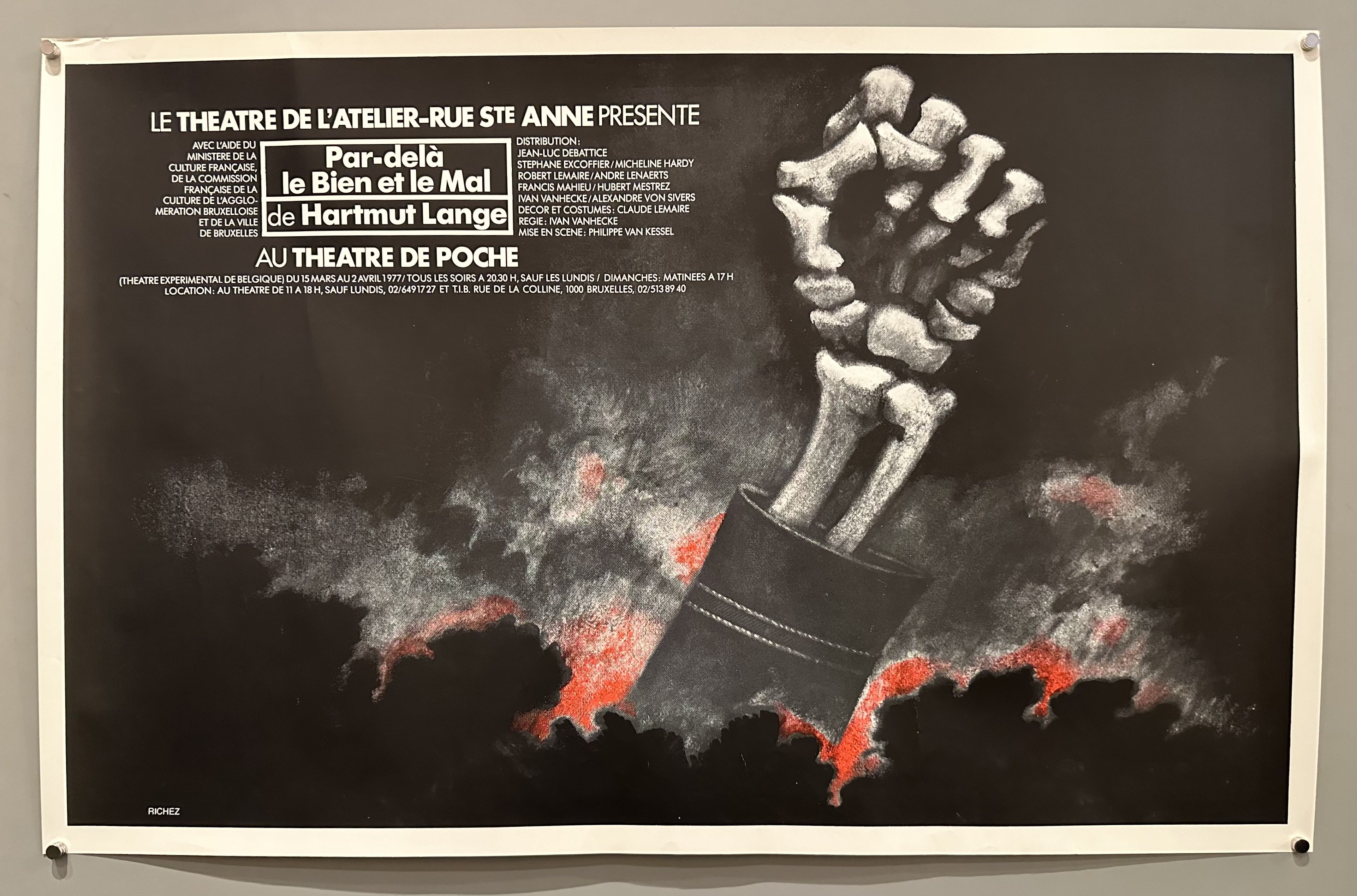 The poster features a skeletal fist in the foreground, with the play's title and other production details in French. The theater poster for the play "Par-delà le Bien et le Mal" (Beyond Good and Evil) by Hartmut Lange