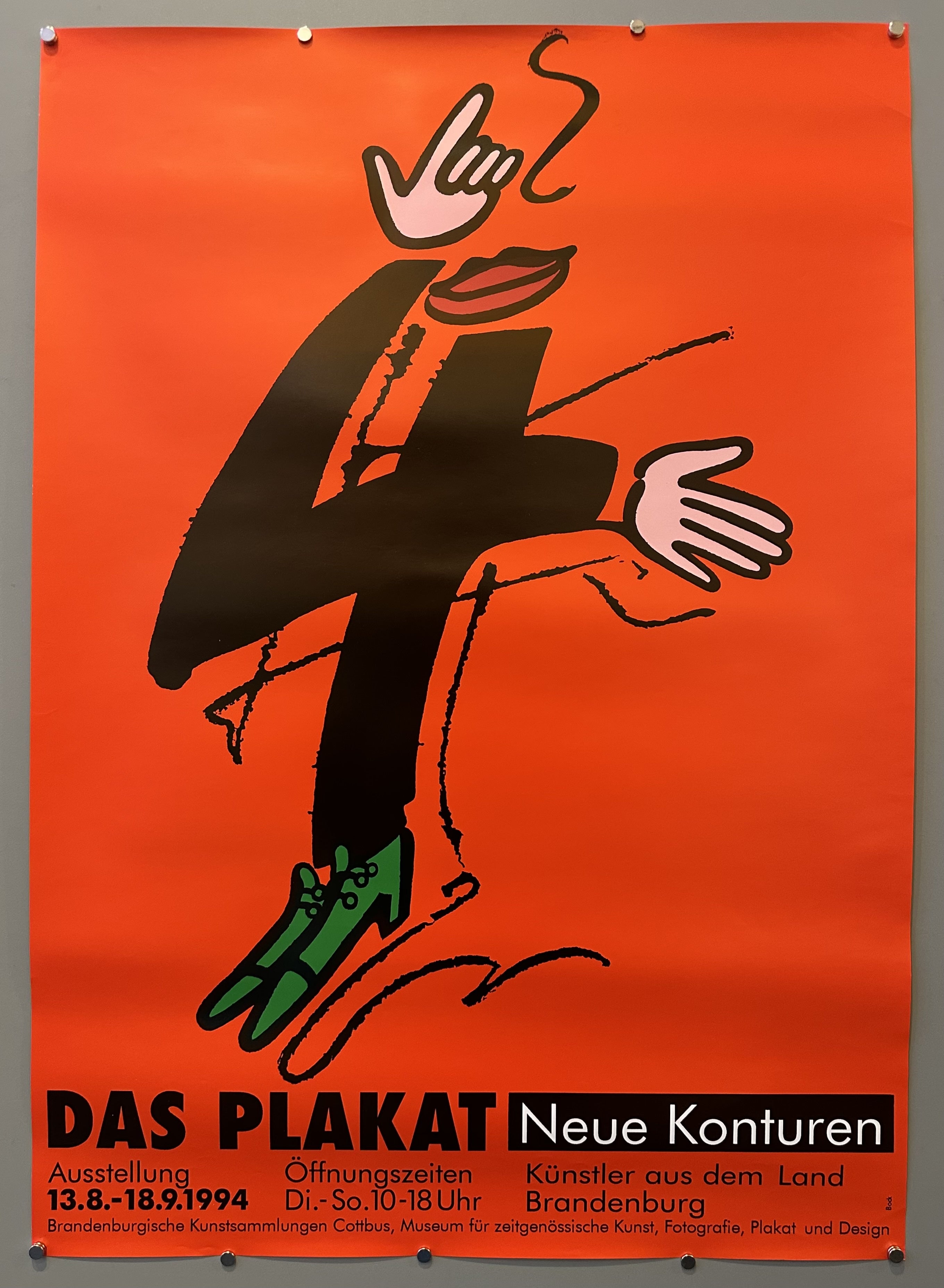 Red poster with an abstract figure with lips and green shoes in the center to promote an art exhibition in Germany.