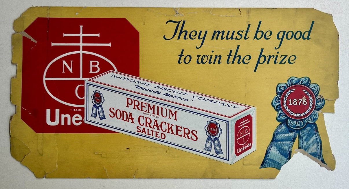 A vintage advertisement for National Biscuit Company's "Premium Soda Crackers Salted," featuring a box of the crackers and the company's "Uneeda Bakers" logo with the text "They must be good to win the prize" and a ribbon with "1876" on it.
