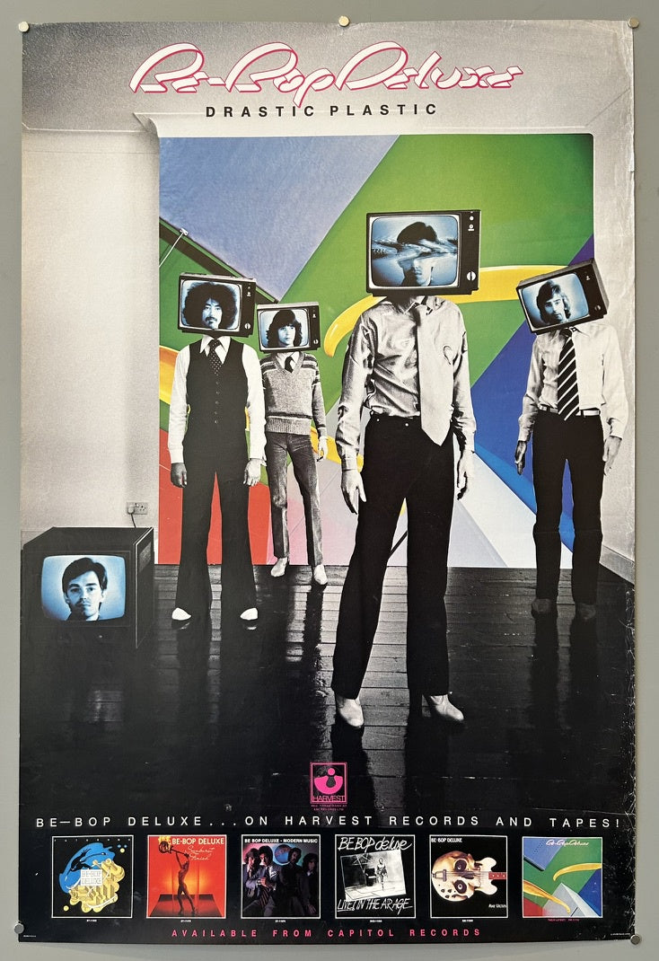 Figures with televisions for heads, standing in a stark, modern setting. Below them are smaller images of other Be-Bop Deluxe album covers, and text indicating the album is available on Harvest Records and Tapes, and from Capitol Records