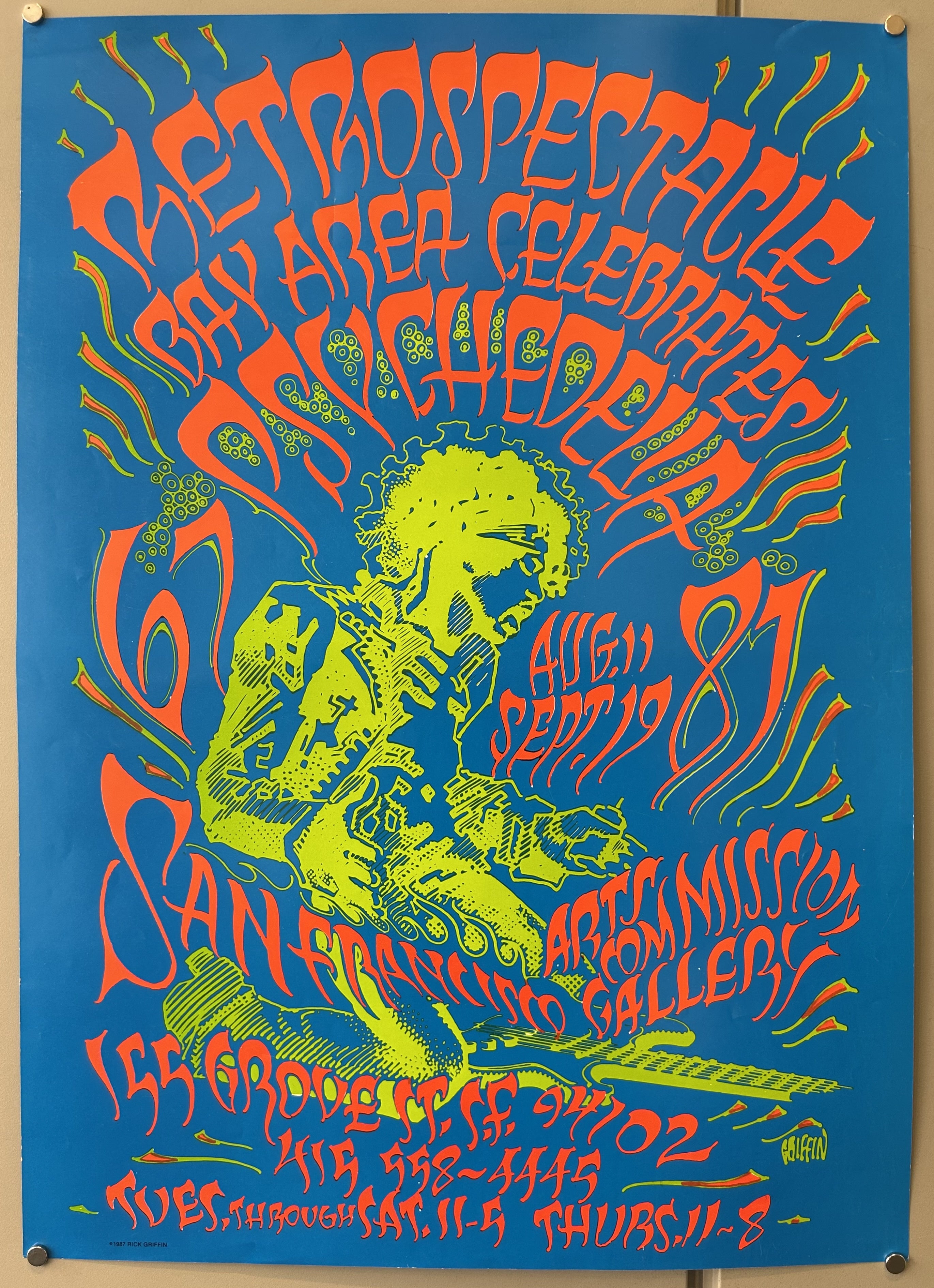 Blue, green, and red psychedelic poster with man playing guitar in middle.
