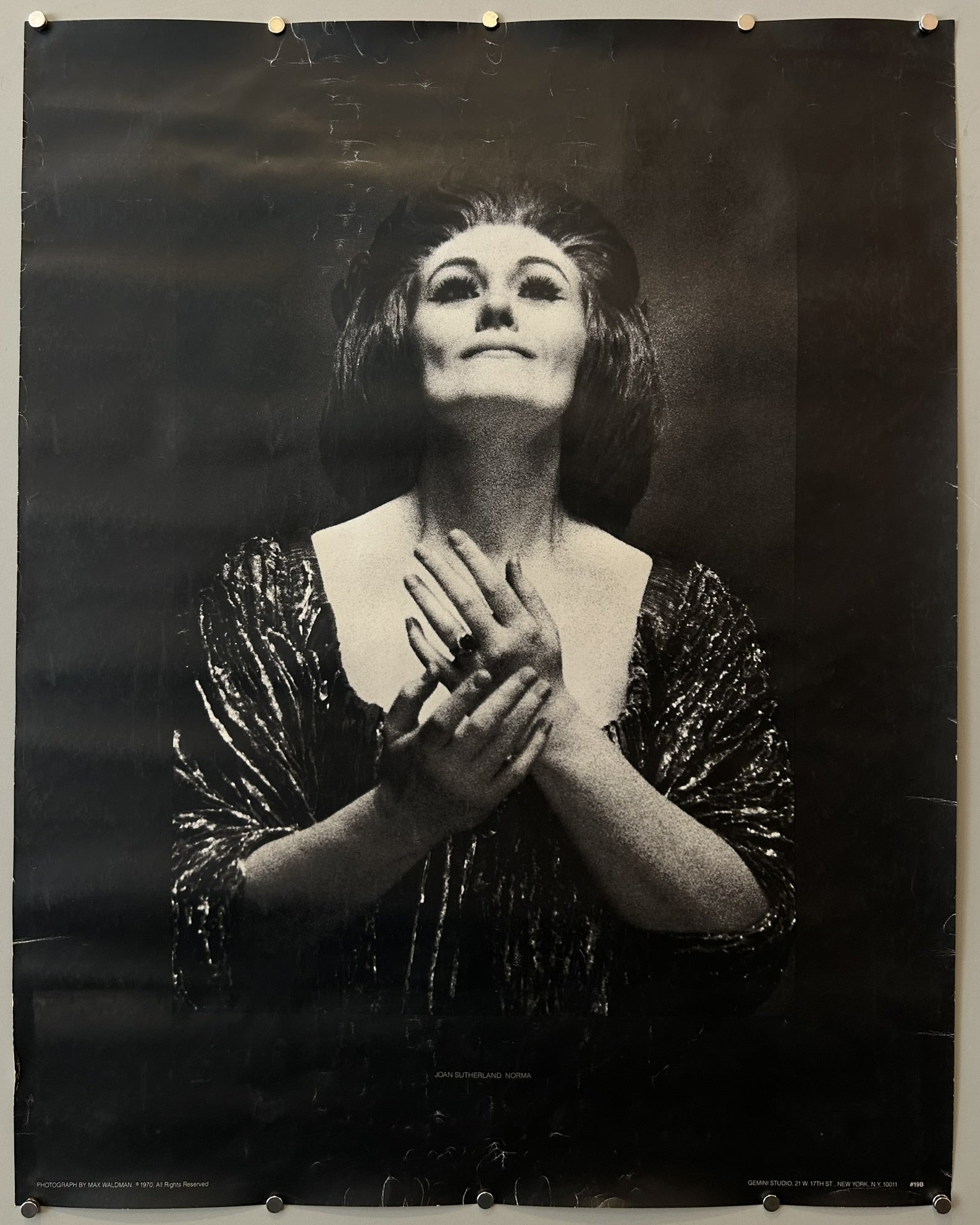This specific poster captures Australian soprano Dame Joan Sutherland in the title role of Vincenzo Bellini's opera, Norma. The photograph used for the poster was taken by M. Waldman.