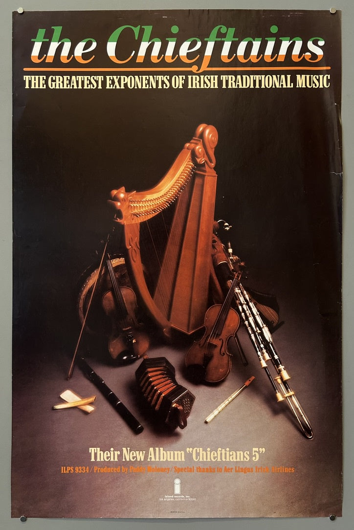 A dark-toned poster for "the Chieftains," featuring the text "THE GREATEST EXPONENTS OF IRISH TRADITIONAL MUSIC." The image displays various Irish musical instruments, including a large wooden harp, a fiddle, uilleann pipes, a concertina, and a flute.