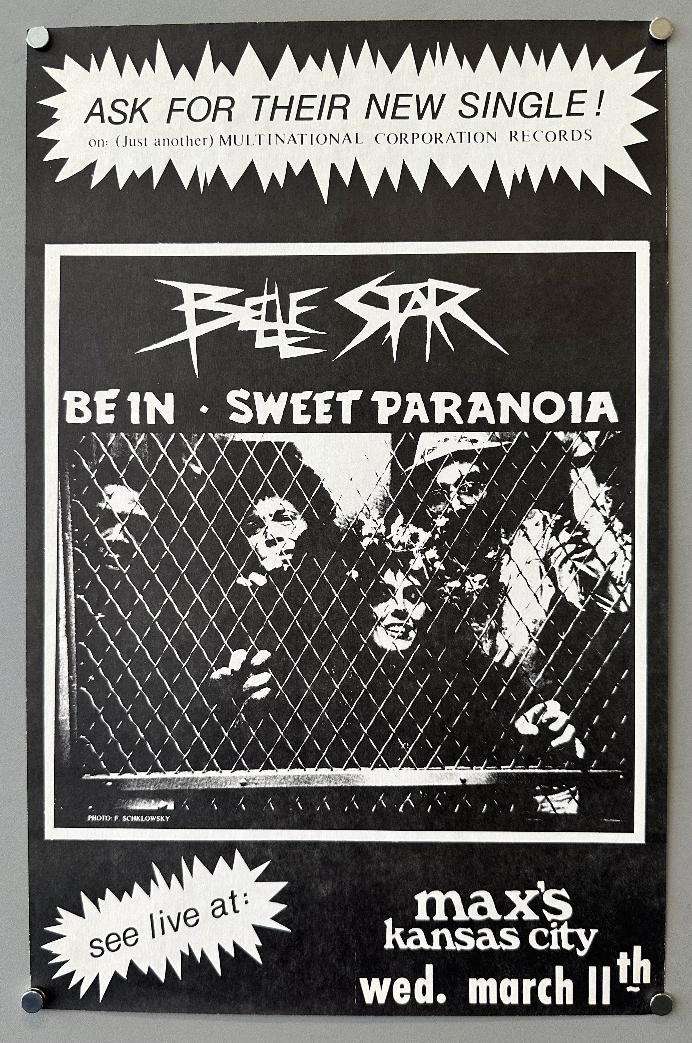A black and white poster for the band Belle Star's new single "Be In / Sweet Paranoia," promoting the single on "Multinational Corporation Records" and announcing a live performance at Max's Kansas City on Wednesday, March 11th. The central image features band members behind a chain-link fence, with "PHOTO F. SCHKLOWSKY" credited at the bottom.