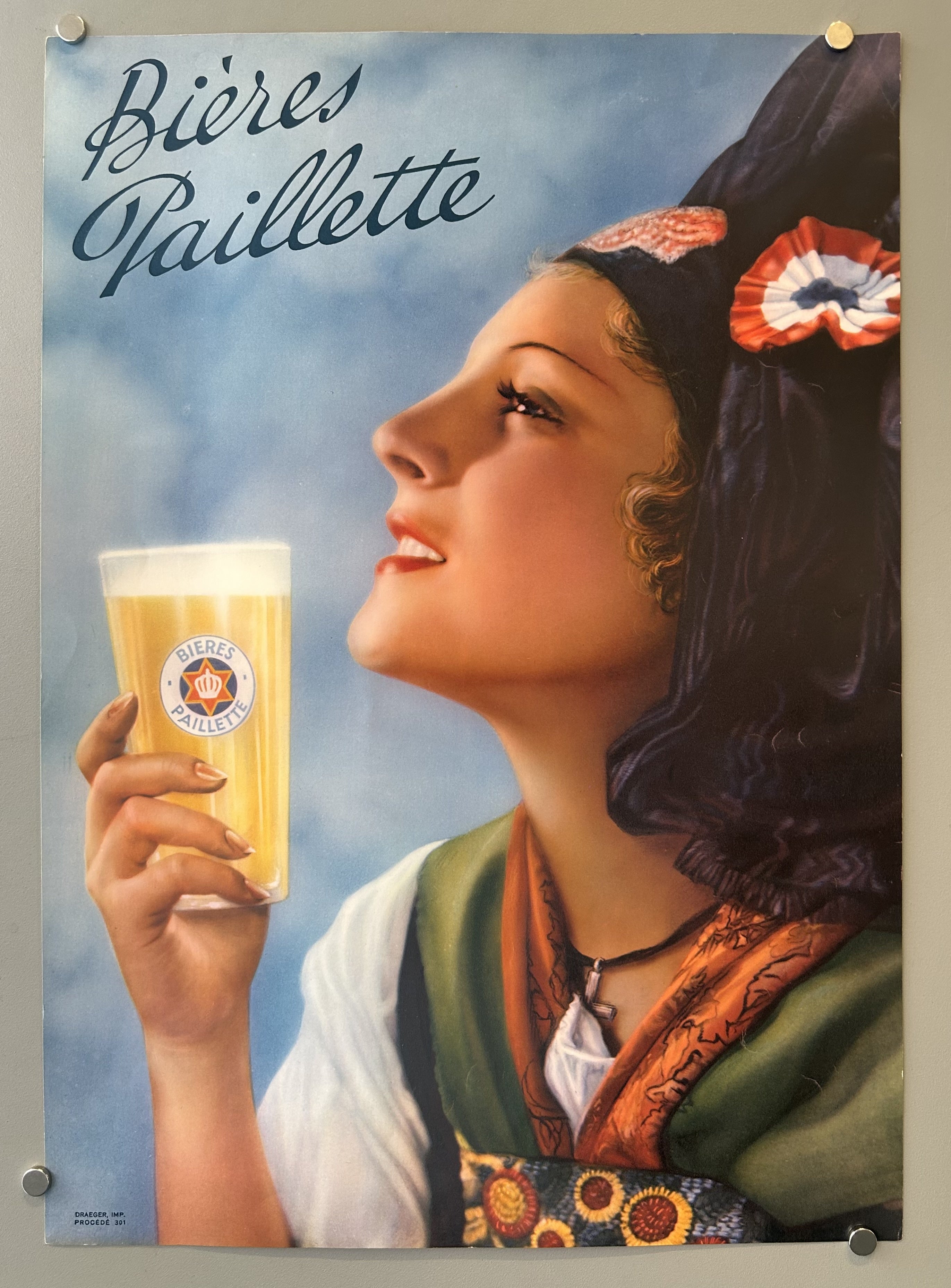 Illustration of a woman holding a beer stein looking happily up in vintage ad for Bieres Paillette.