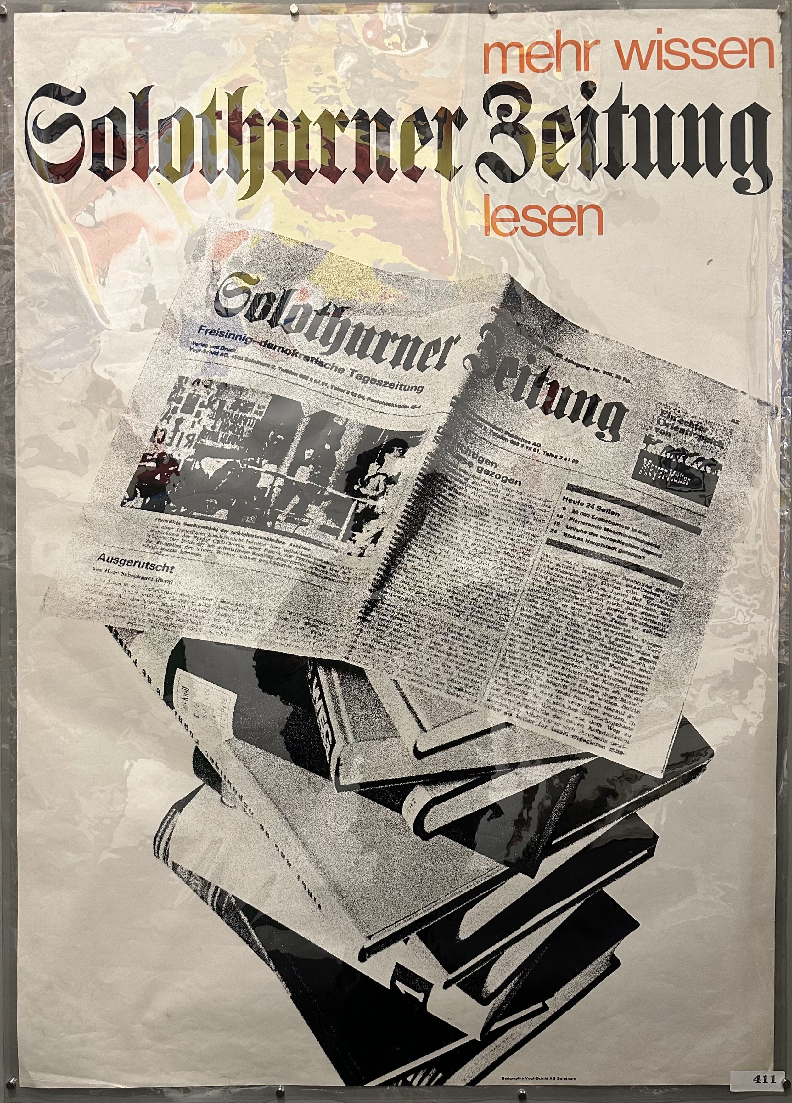 Stack of books with a newspaper open on top for local Swiss newspaper advertisement.