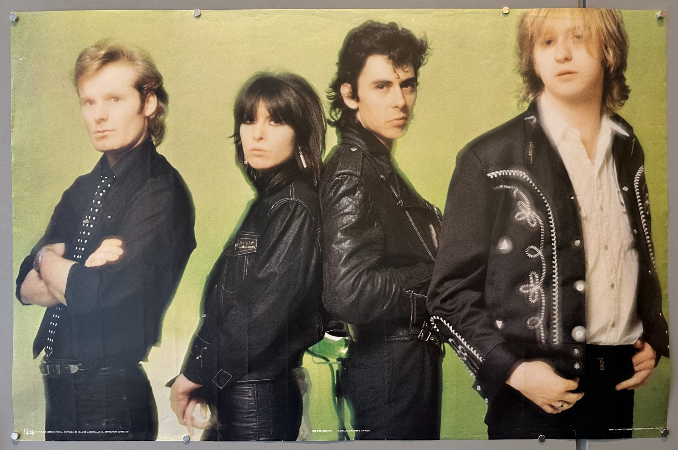 The Pretenders from their album "Pretenders II." The poster features the four band members: Chrissie Hynde, James Honeyman-Scott, Pete Farndon, and Martin Chambers. They are posed in a line against a lime green background.