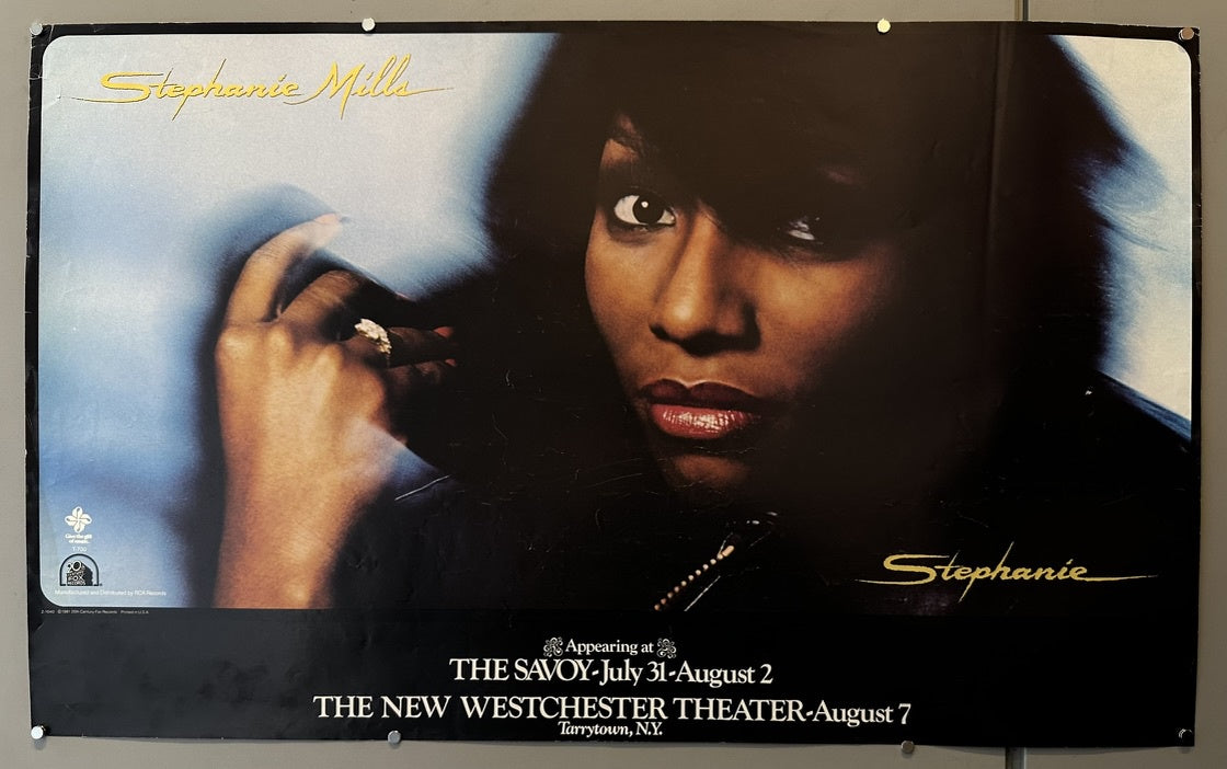 A promotional poster for Stephanie Mills featuring a close-up image of her and details about her performances. Text on the poster includes: "Stephanie Mills," "Stephanie," and "Appearing at THE SAVOY-July 31-August 2 THE NEW WESTCHESTER THEATER-August 7 Tarrytown, N.Y."