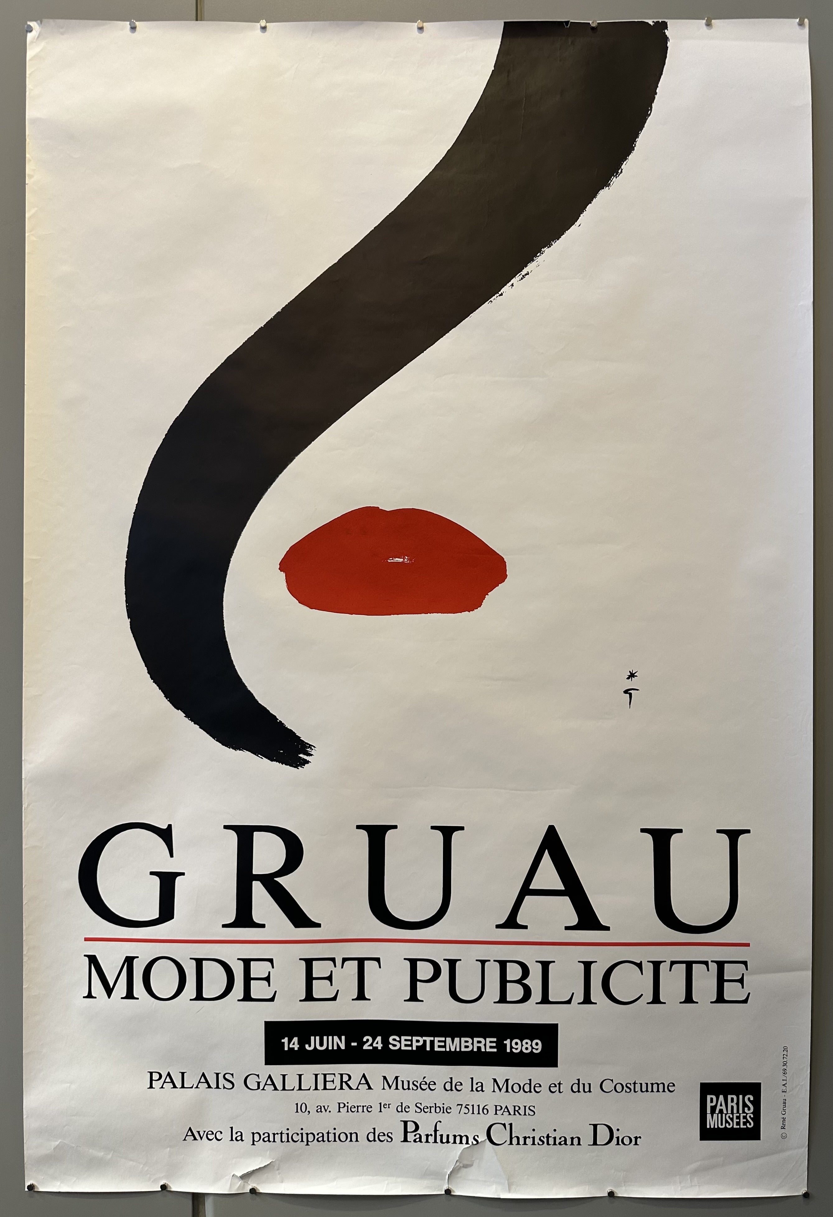 Red lipstick and a streak of black hair are the focal point of this poster promoting Gruau's exhibition at the Palais Galliera.
