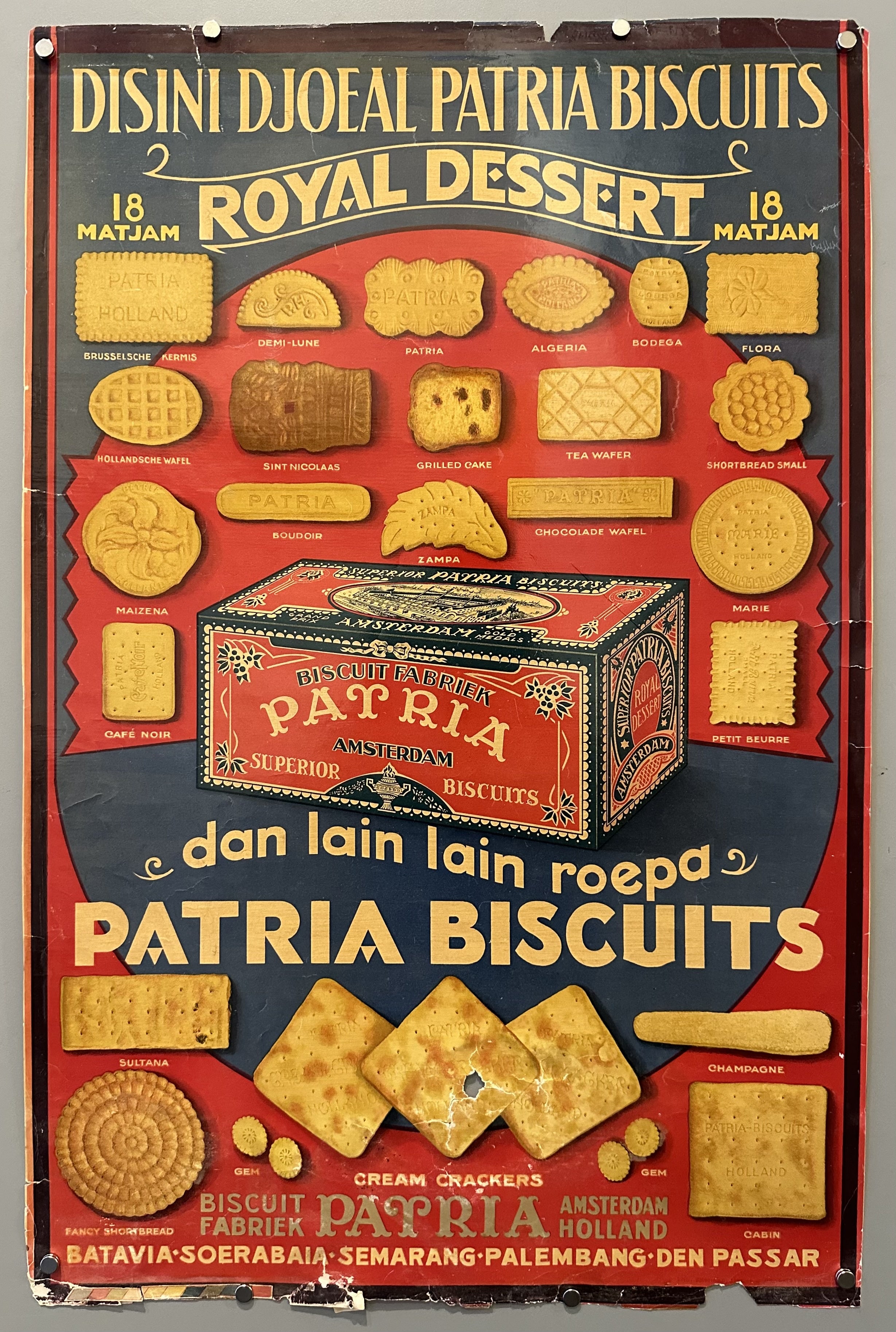 Various biscuits from Patria are illustated in red and blue poster in Malay or Indonesian during Dutch occupation of Indonesia.