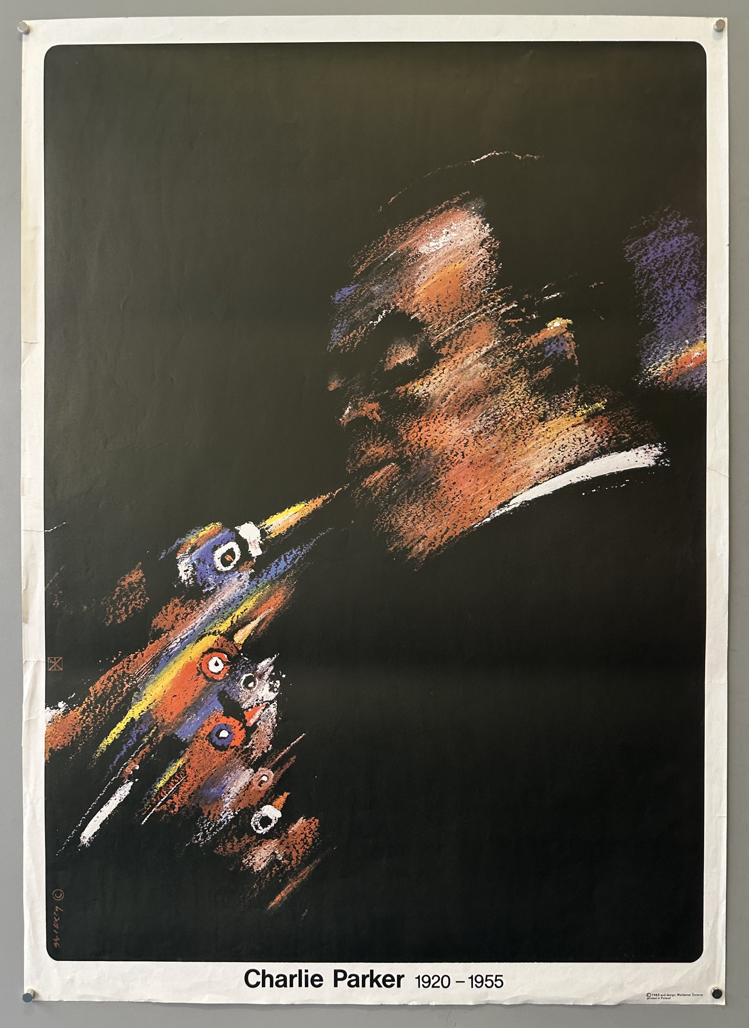 Charlie Parker plays against a black background, his trumpet and face in motion and the only colored images in the commemorative poster.