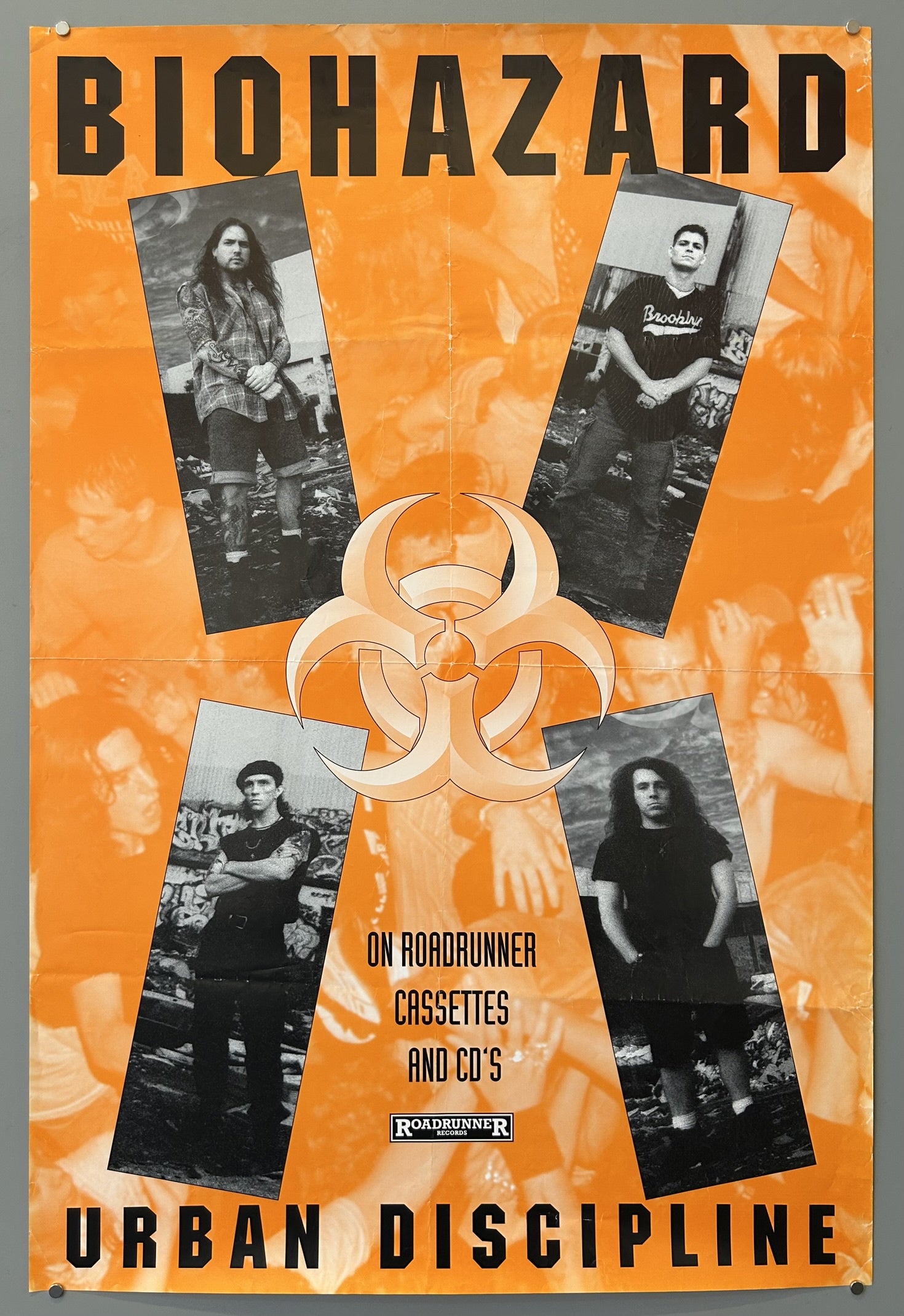 An orange poster featuring the band Biohazard and promoting their album "Urban Discipline." The poster has a large "BIOHAZARD" at the top and "URBAN DISCIPLINE" at the bottom.