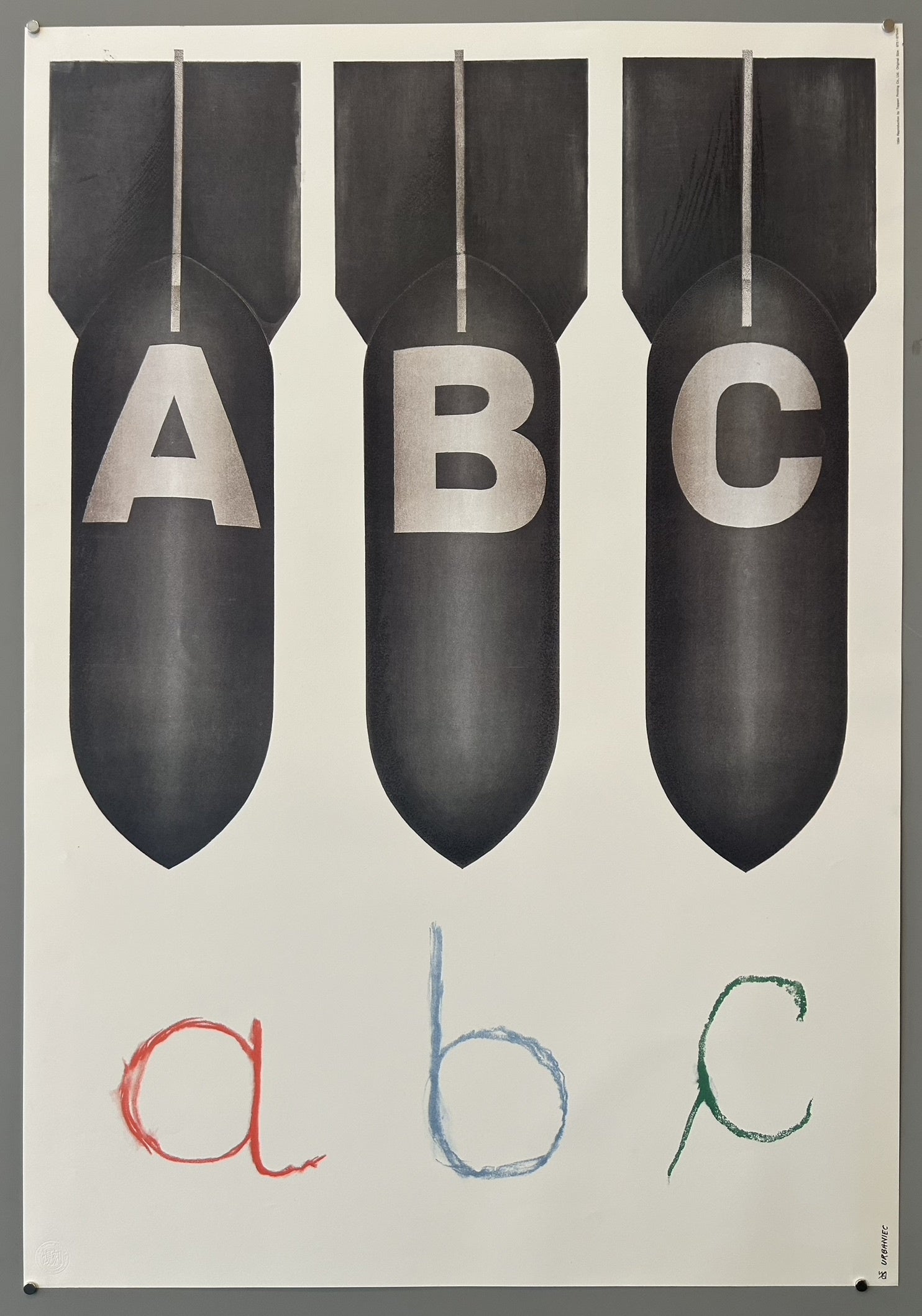 The poster prominently features three large, dark bombs at the top, each bearing a capital letter (A, B, C), representing the destructive power of nuclear weapons. Below, three smaller, colorful, handwritten lowercase letters (a, b, c) symbolize the innocence and vulnerability of children and education, contrasting sharply with the threat above.