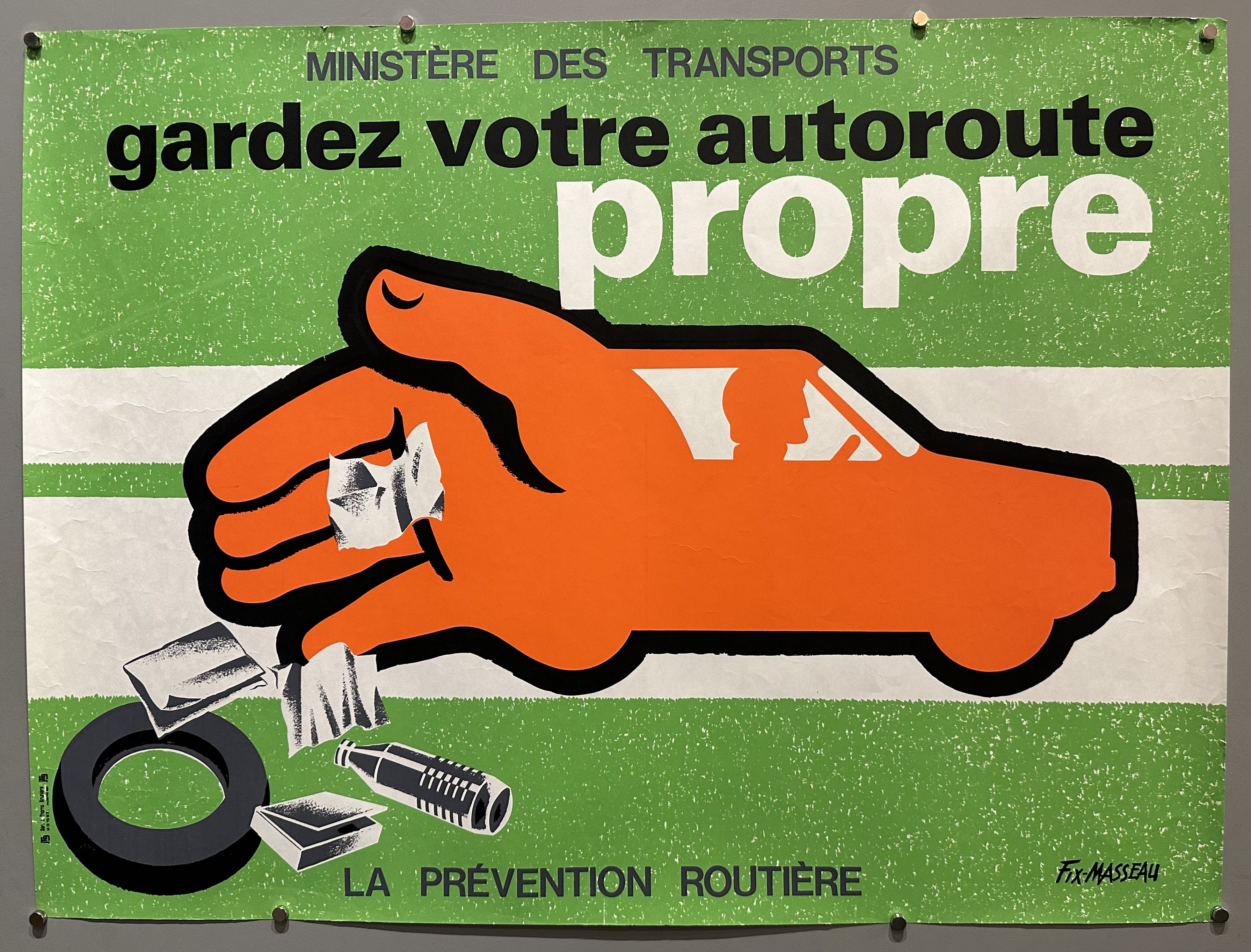 A car turns into a hand towards the back with the hand dropping car parts as the driver continues down the road.