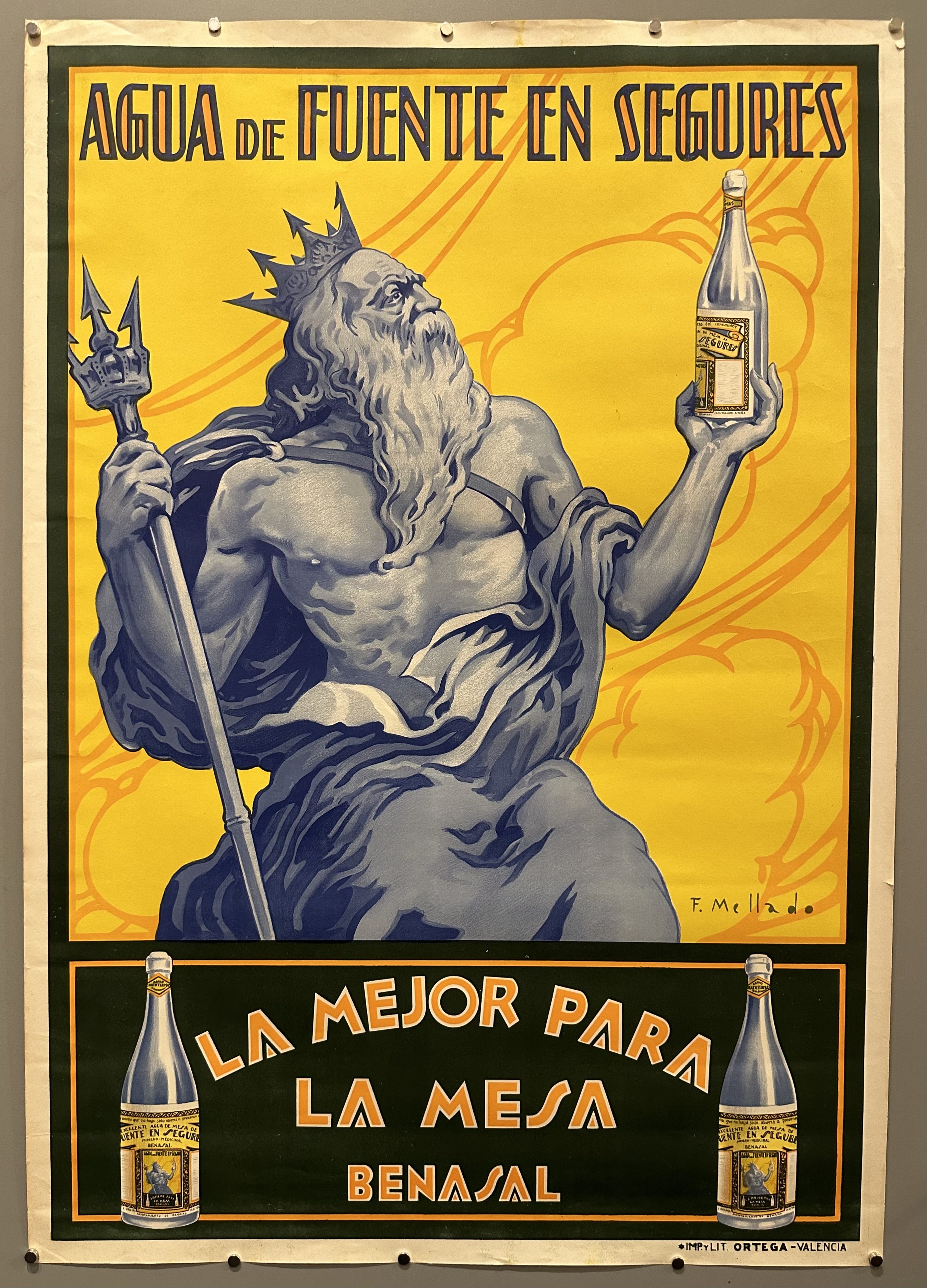 Triton holds a bottle up in his hand to advertise a brand of Spanish alcohol