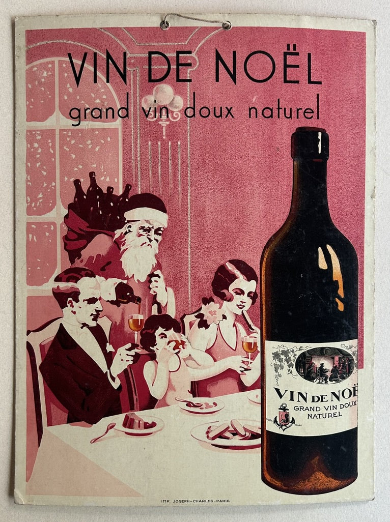 Features Santa Claus, a family (man, woman, child) enjoying wine and dessert, and a prominent bottle of the advertised wine.