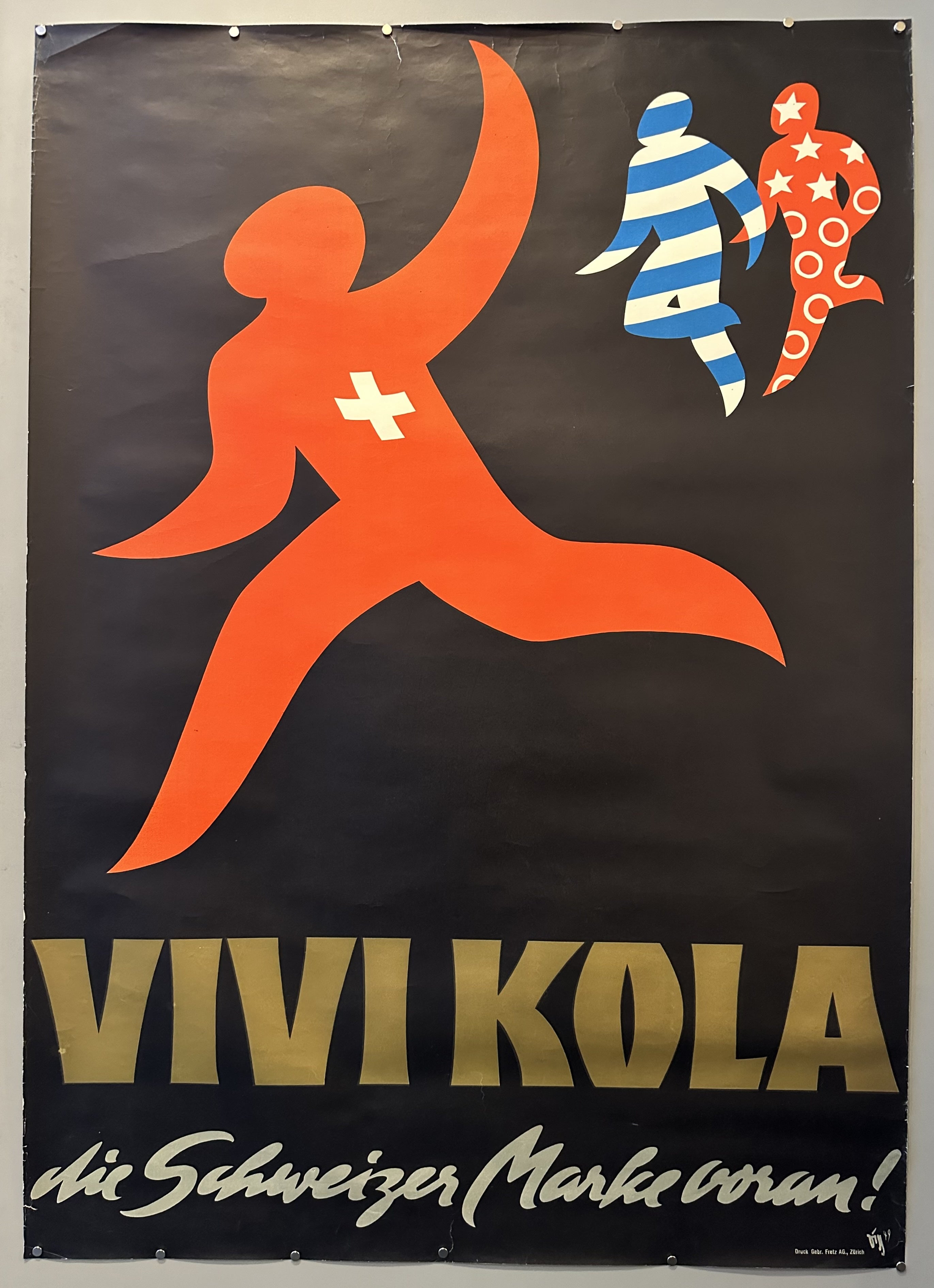 Swiss flag figure waves to his friends to join him in enjoying Vivi Kola.