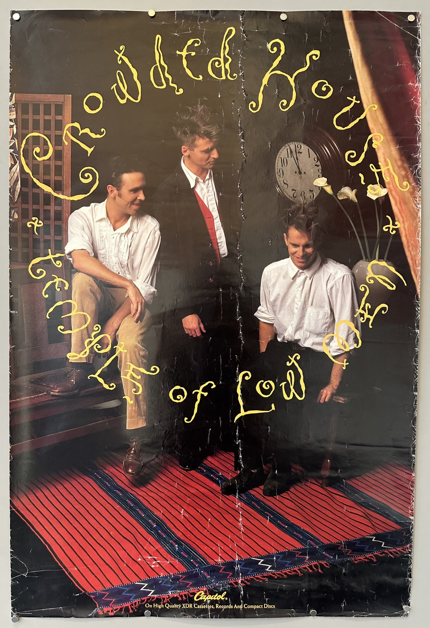 The poster features the band members, including Neil Finn, known for writing the song, in a somewhat stylized setting that aligns with the album's title, Temple of Low Men