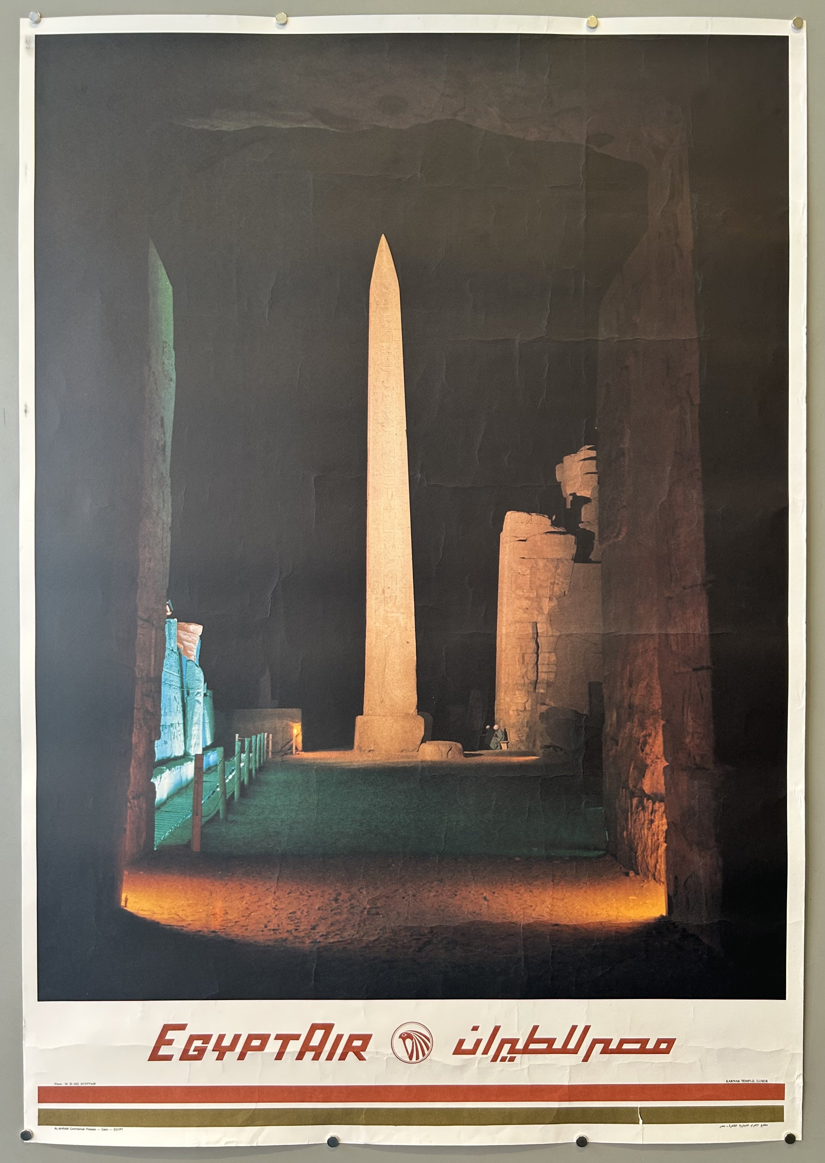 Photograph of Karnak Temple in vintage travel poster from Egypt Air, Egypt Air logo is at bottom with Arabic version next to it.