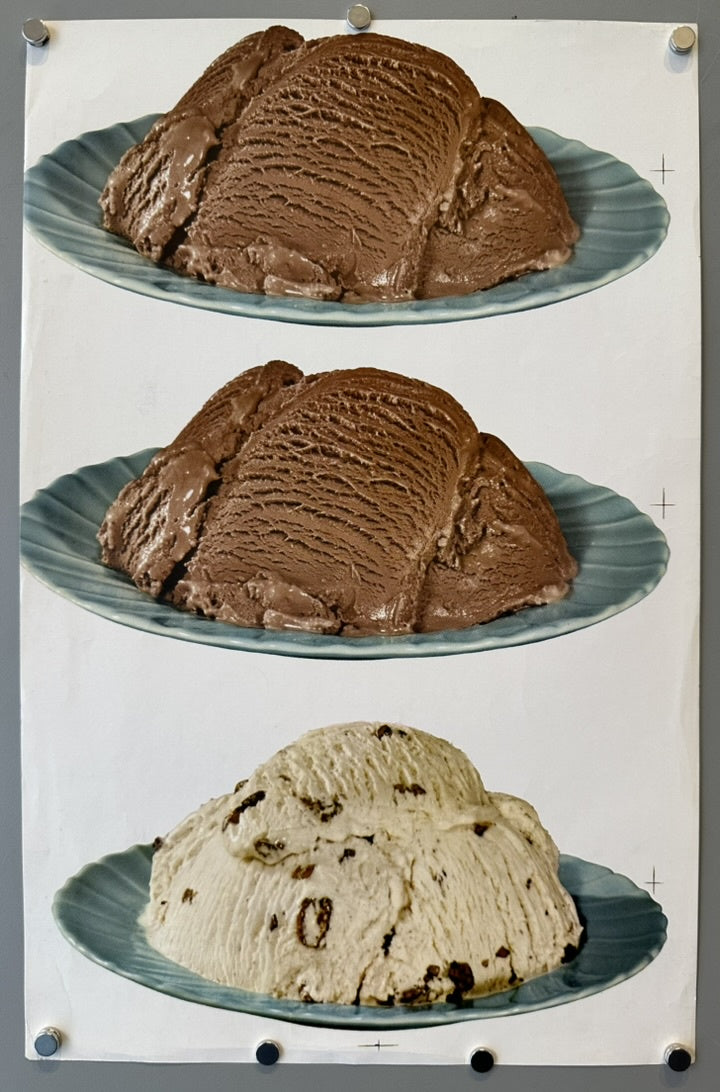 This image shows three plates of ice cream. The top two plates feature chocolate ice cream, while the bottom plate has a lighter-colored ice cream with chocolate chips. The plates are light blue with a ridged texture, and the background is a plain gray.
