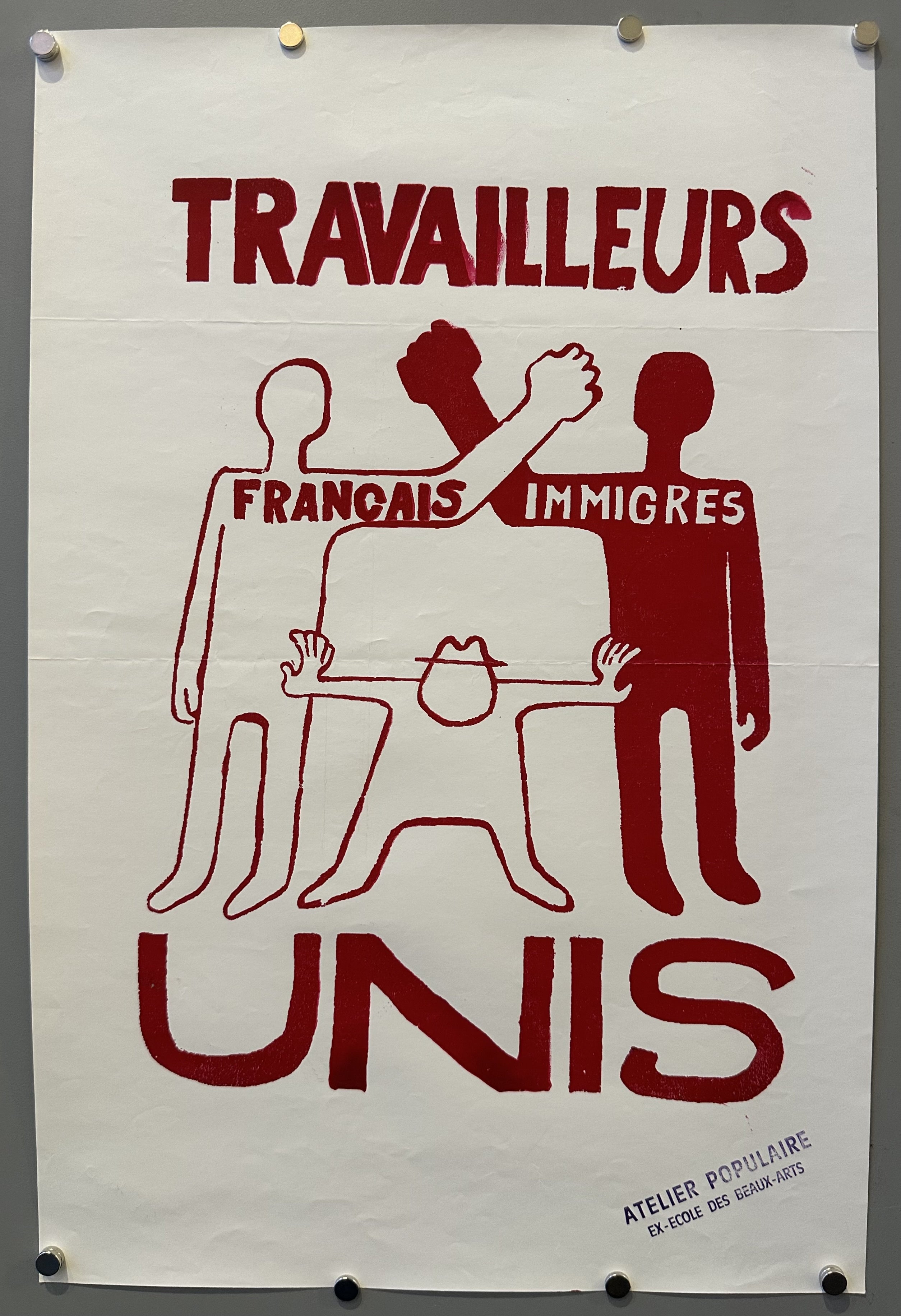 A person representing the French and a person representing immigrant workers link arms as a person tries to stop them in this French political poster.