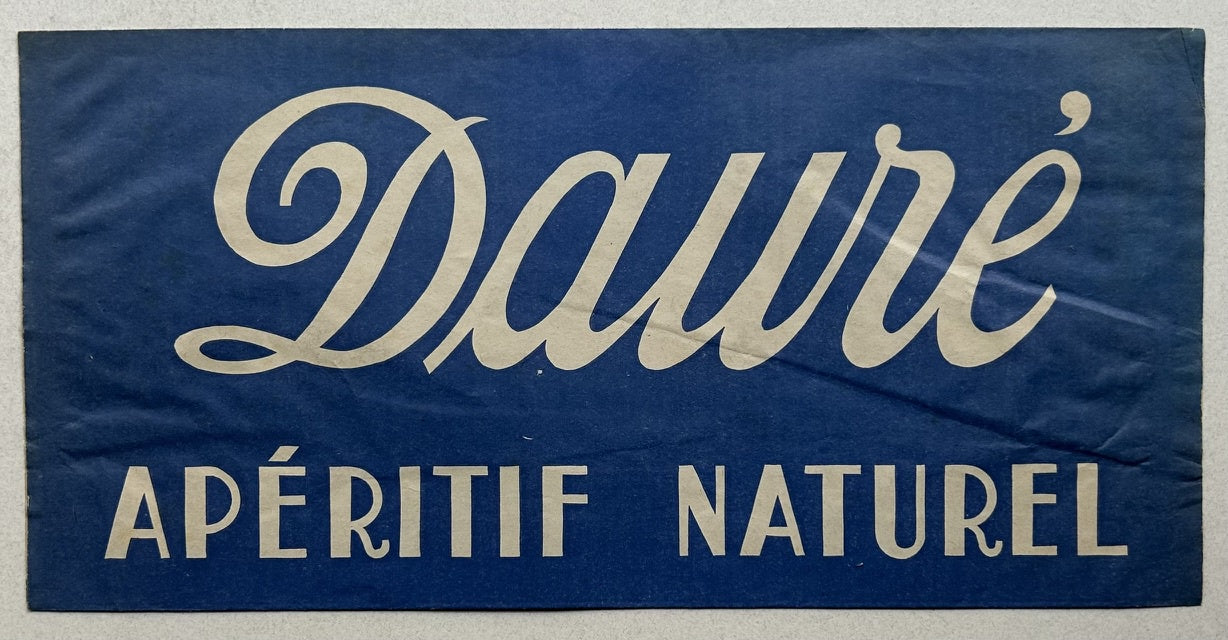 This is a vintage poster advertising Daure Apéritif Naturel, a French wine or spirit. The poster features the brand name "Daure" in a stylized, cursive font, followed by "APÉRITIF NATUREL" in a more straightforward sans-serif font. The background is a solid dark blue color, which contrasts with the light-colored text.