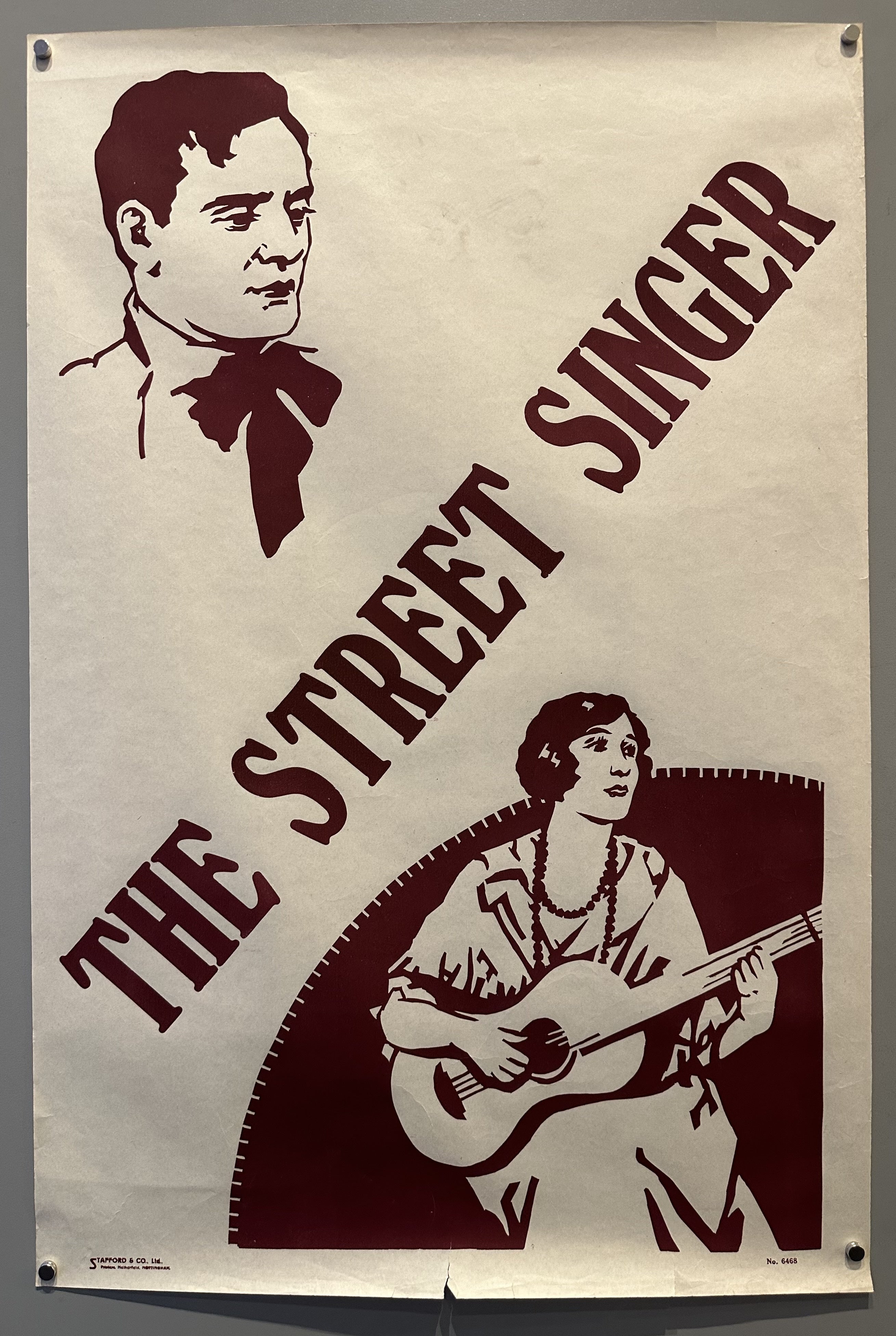"The Street Singer" is diagonally written on the poster with Arthur Tracy's portrait in the top left-hand corner and a woman playing guitar in the opposite one.