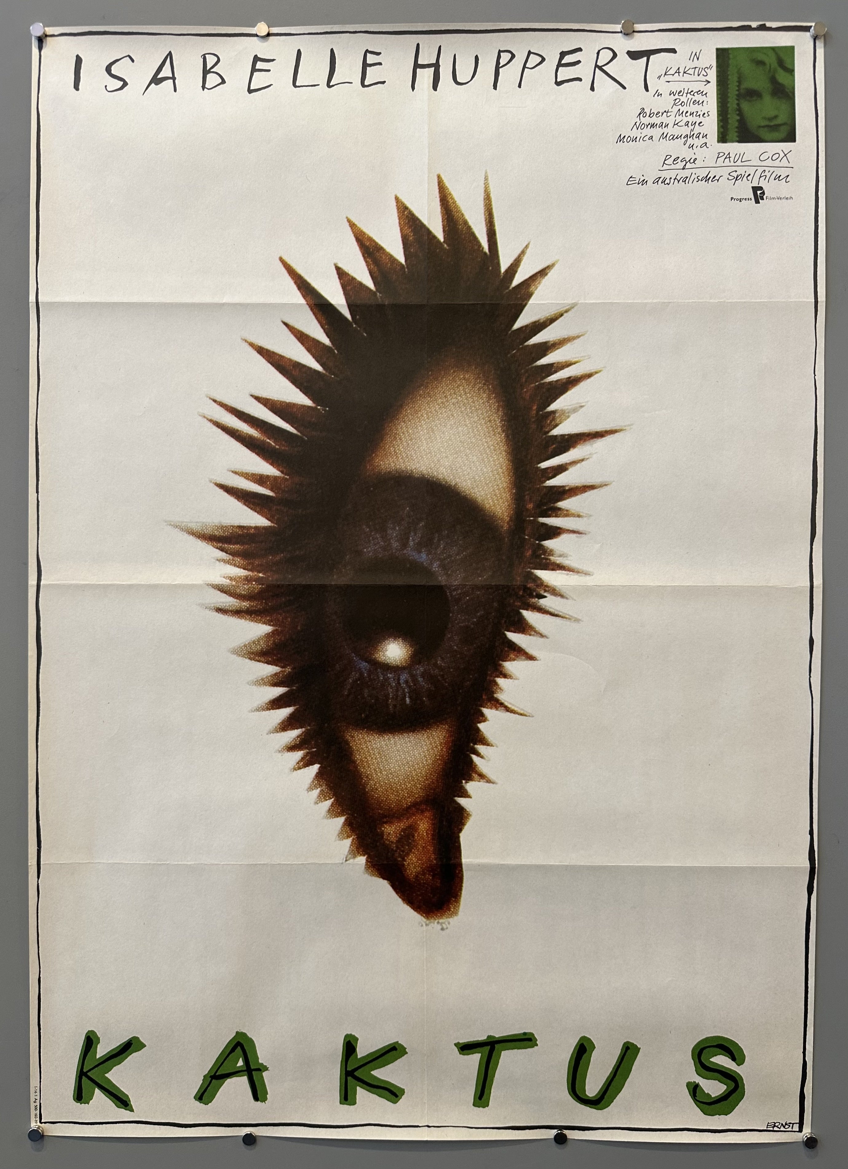 White poster with eyeball in the middle of it and green text for the title of the film (Kaktus).