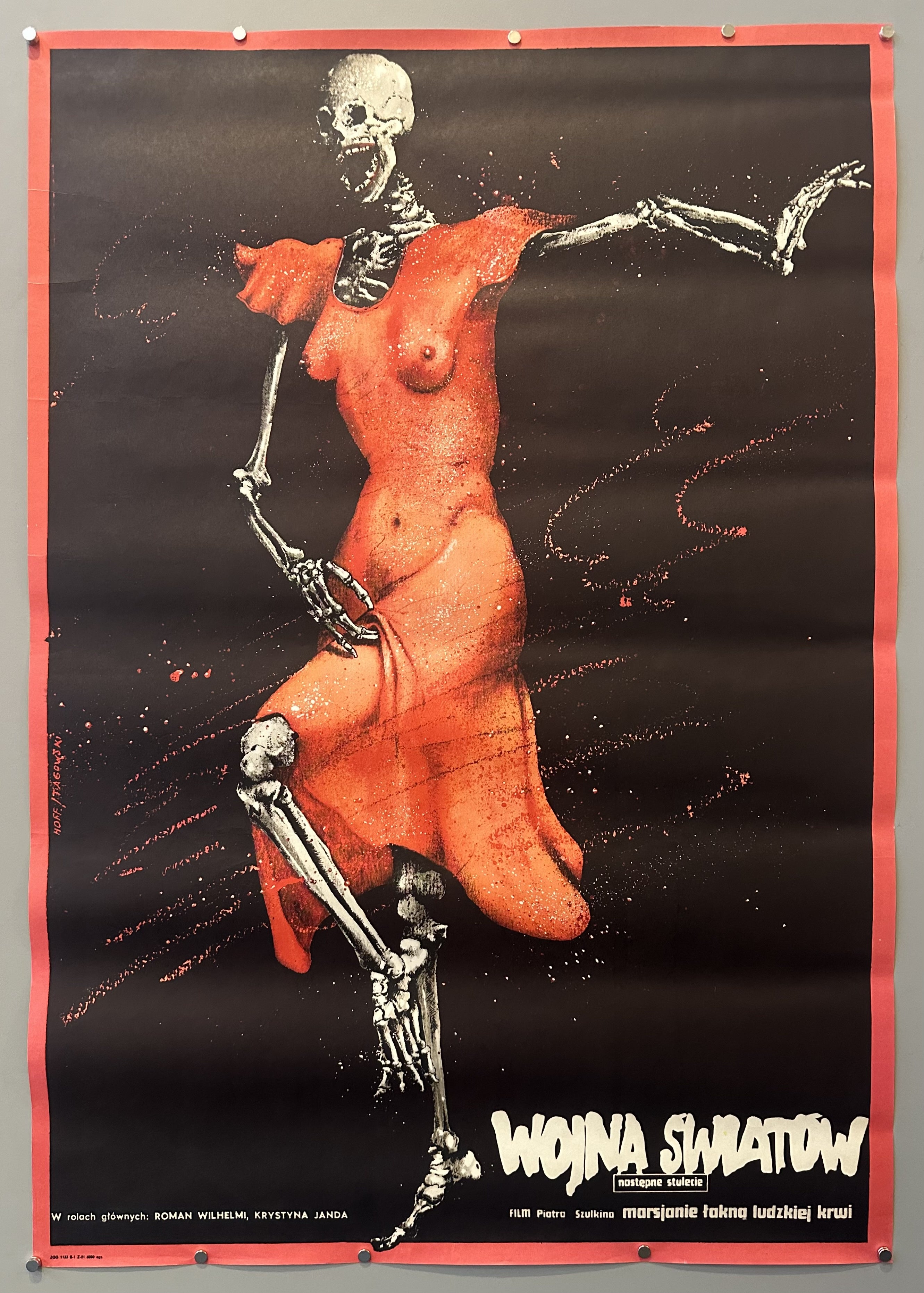 A Polish film poster for 'Wojna Swiatow' (War of the worlds), featured is a skeleton in a red dress standing on one of their toes with its mouth wide open. Below the skeleton in Polish text is information on the text.