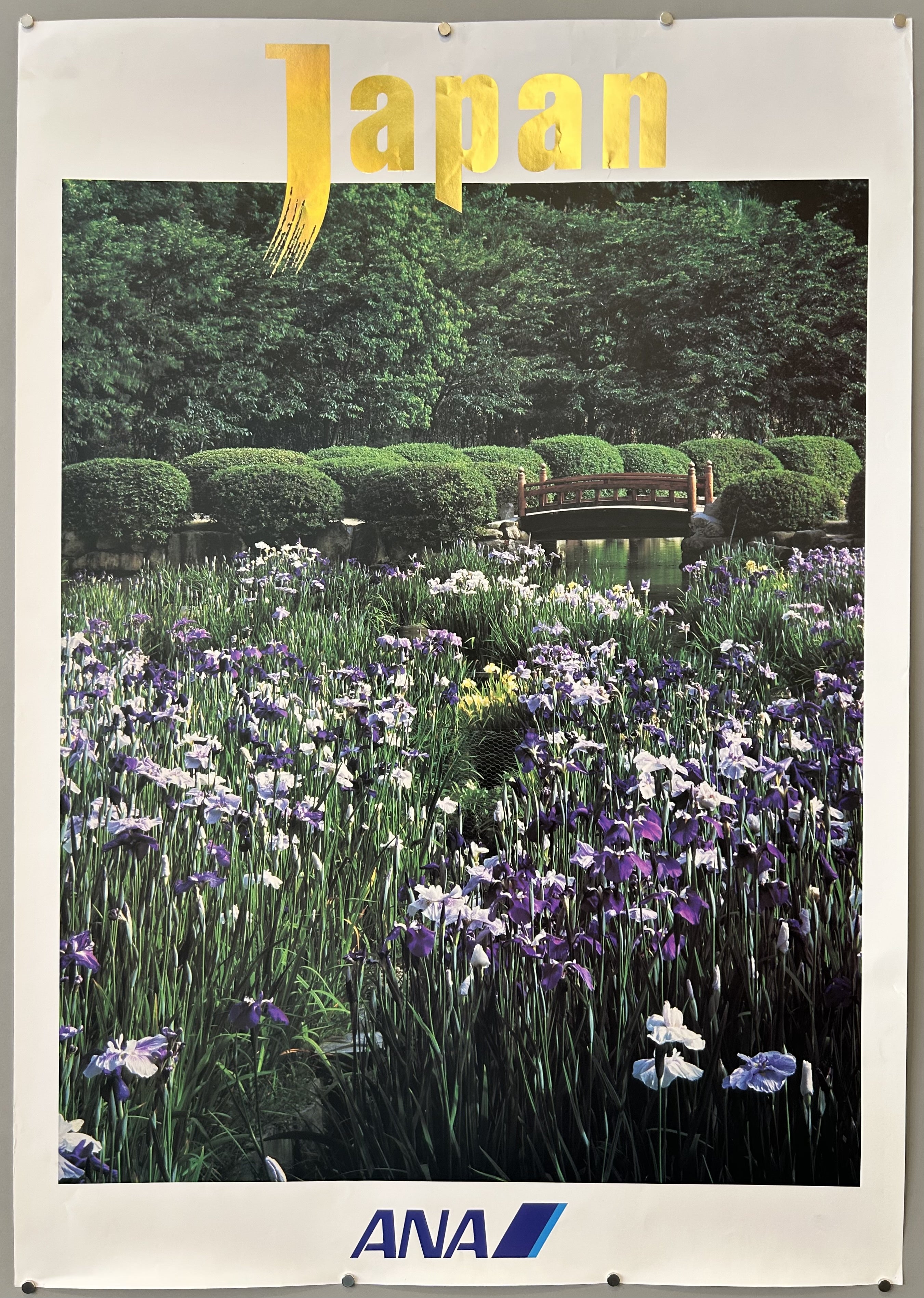ANA travel poster for Japan featuring a photograph of a koi pond surrounded by purple flowers.
