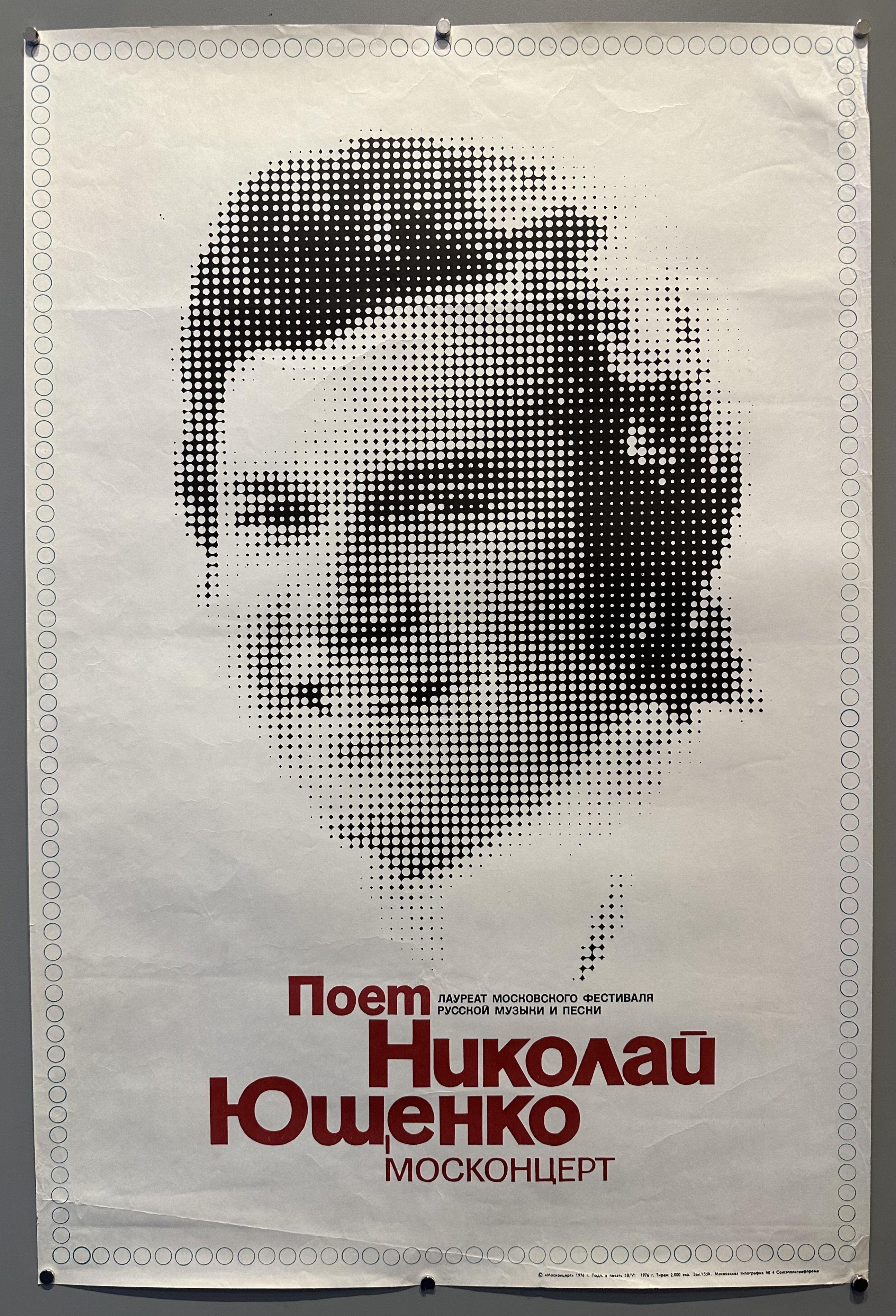 a portrait of man in the center in black and white with a psychedelic look to him with russian red text below.