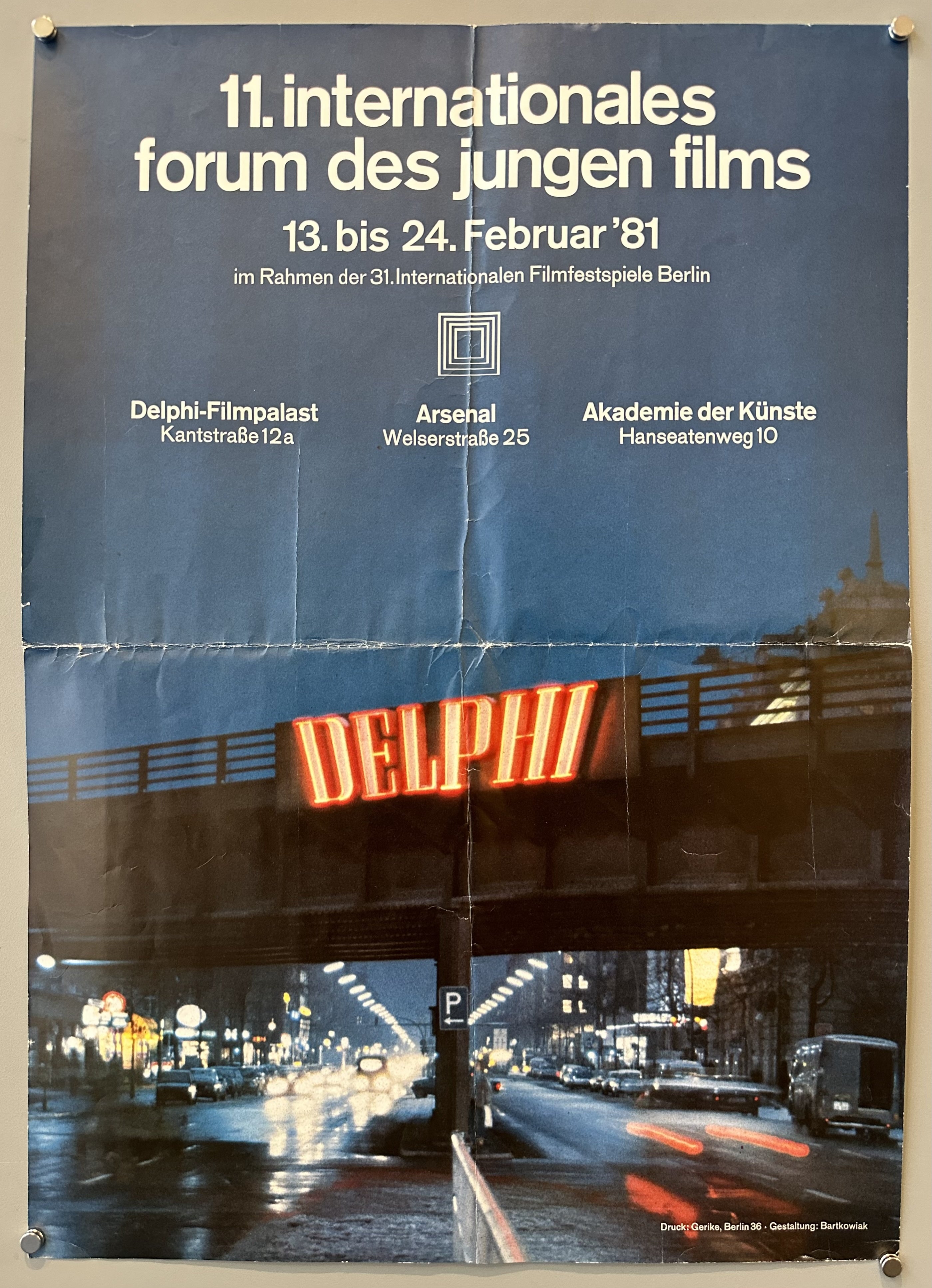 White text with a photograph of a bridge and a busy street at night