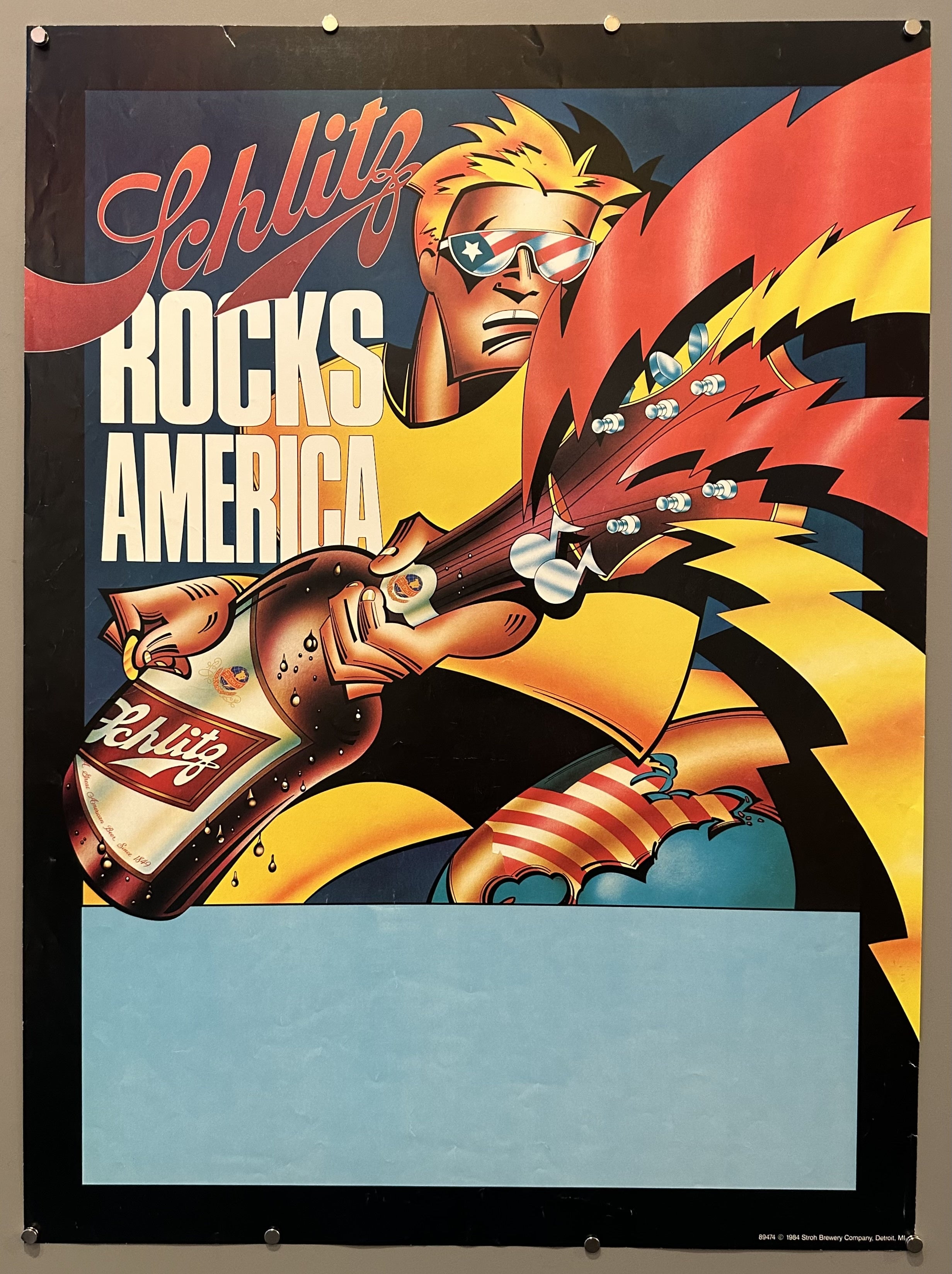 A man plays a guitar shaped like a bottle of beer in advertisement for brewery.