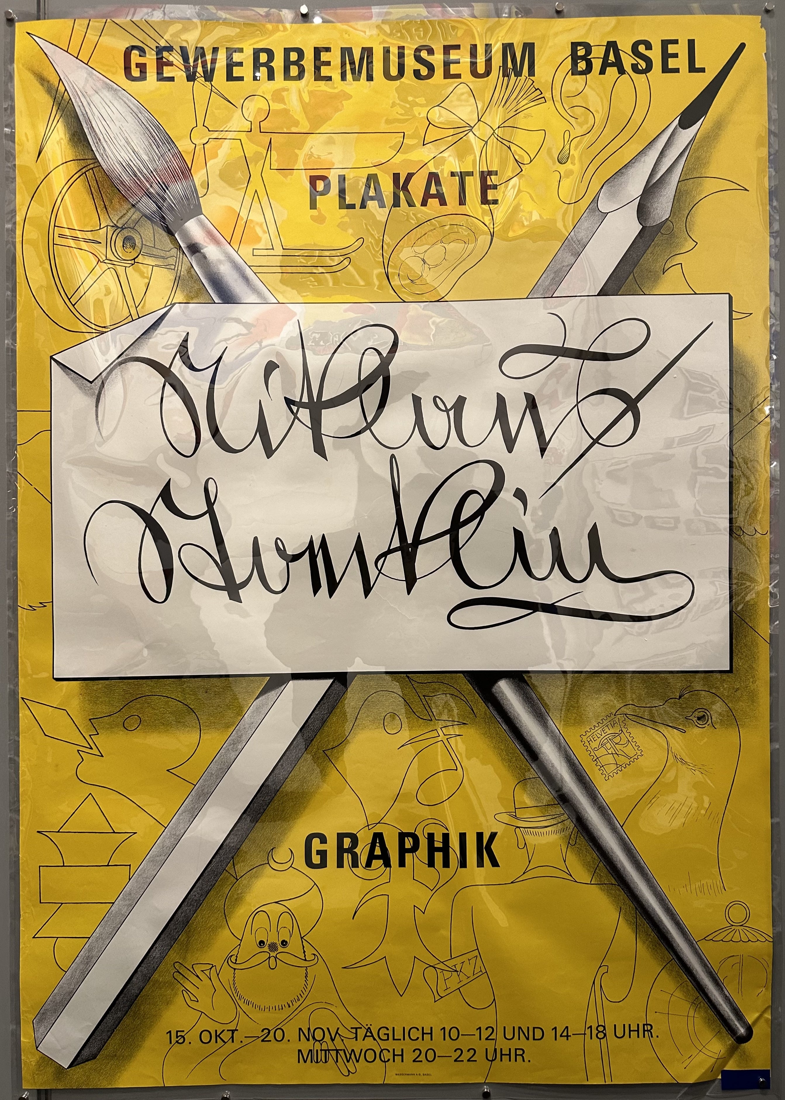 Yellow poster with sketches and large pencil and paintbrush in cross formation for typography exhibition in Switzerland.