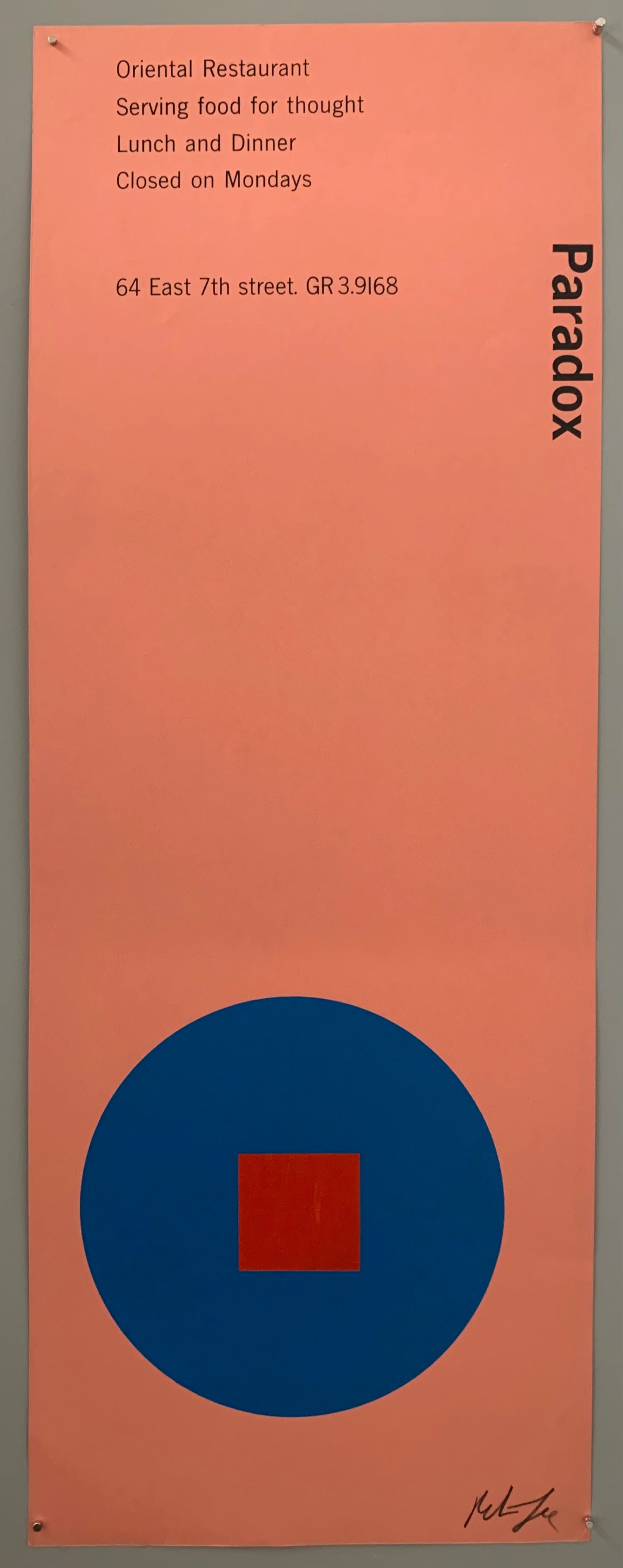 A blue circle with an red square on pink paper.