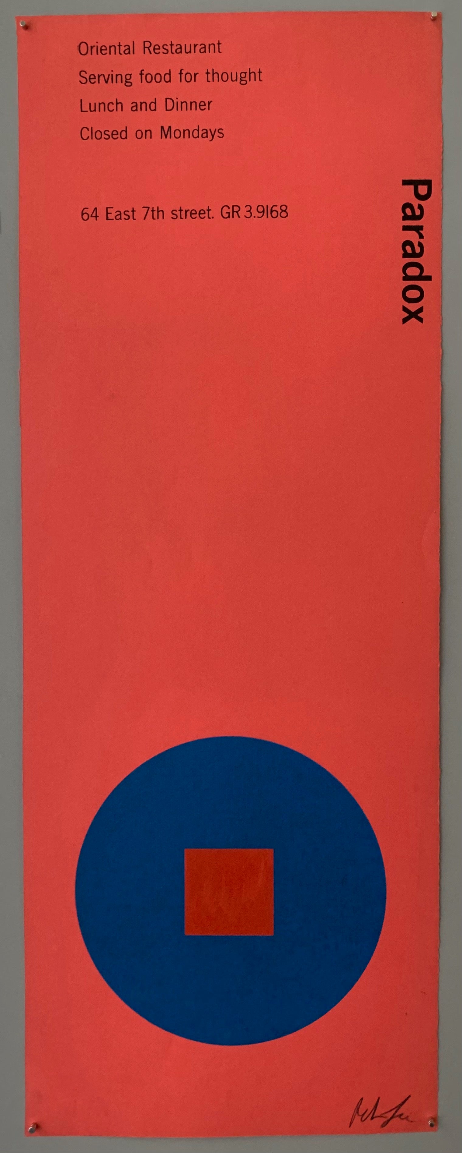 A blue circle with a red square on salmon pink paper.