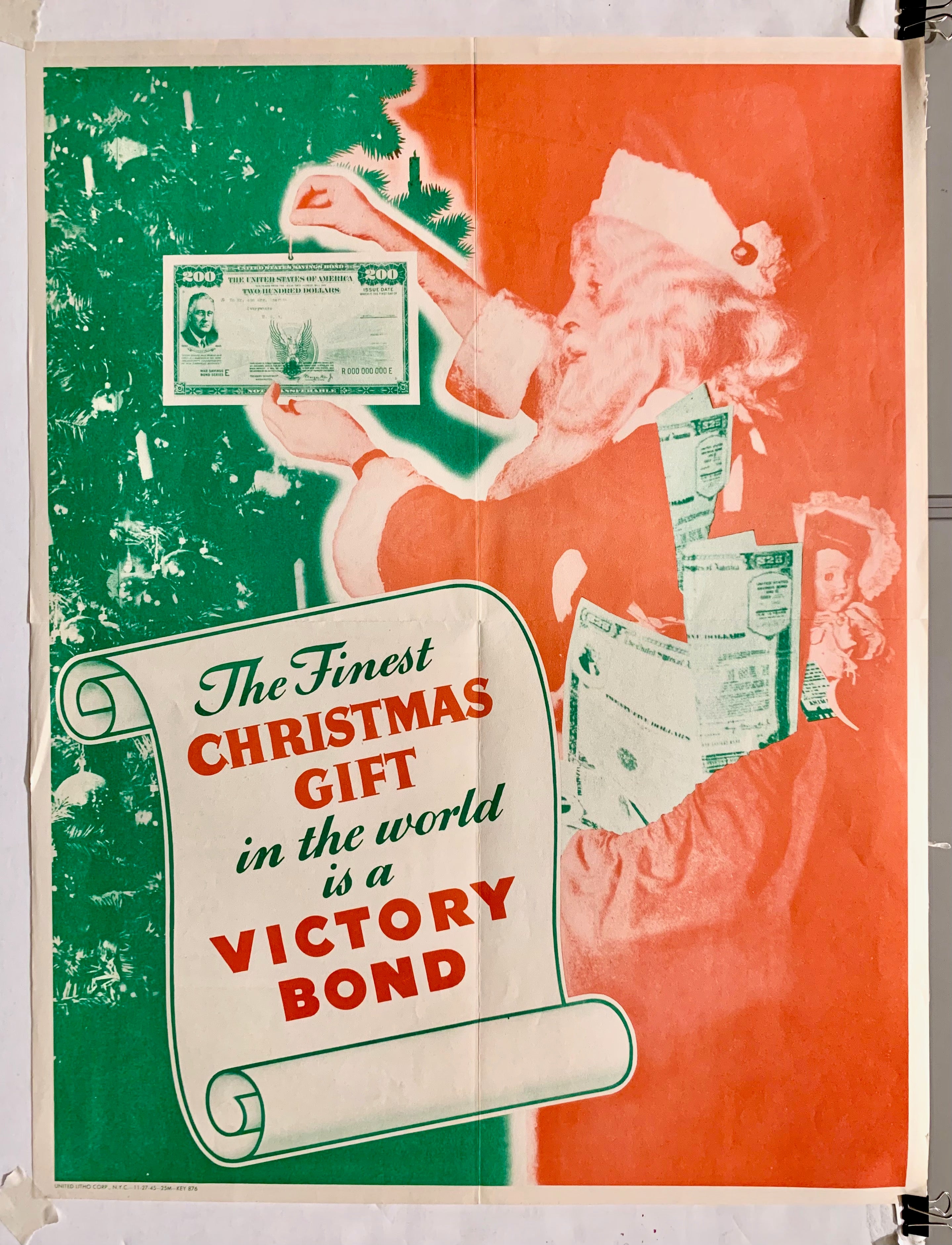 Santa pining a victory bond onto a green christmas tree