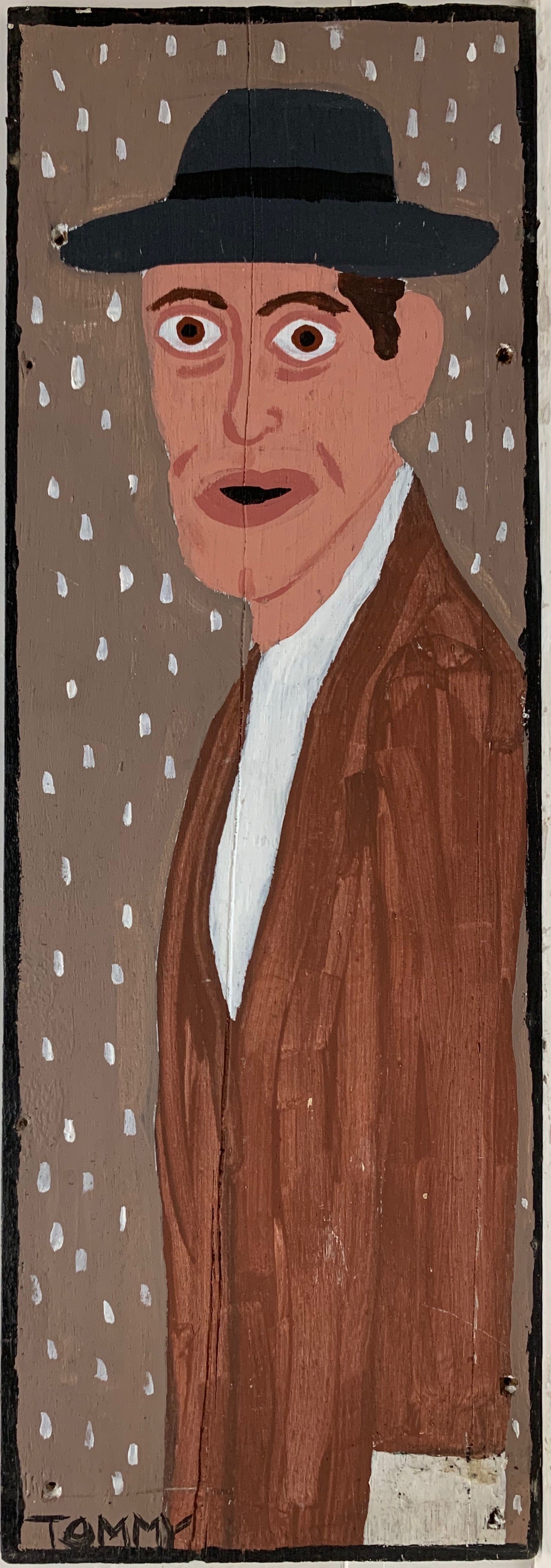 A Tommy Cheng portrait of Willem Dafoe in a black hat and a brown coat.