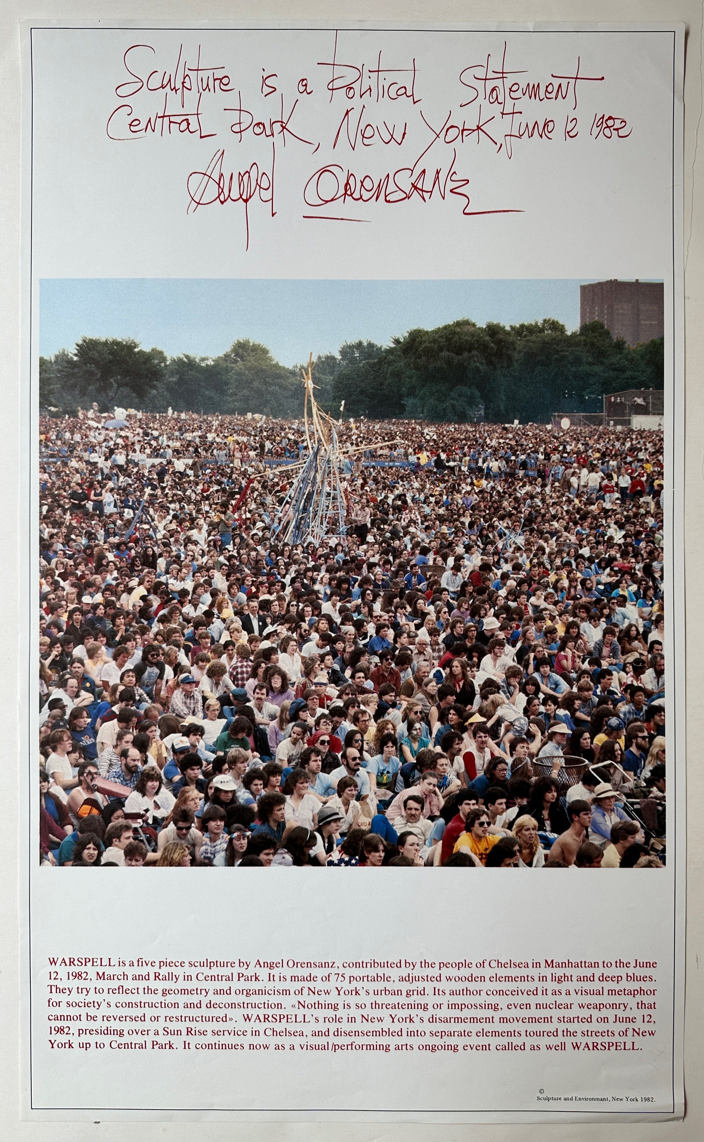 A white poster with red text and a photograph in the middle of people gathered near the sculpture.