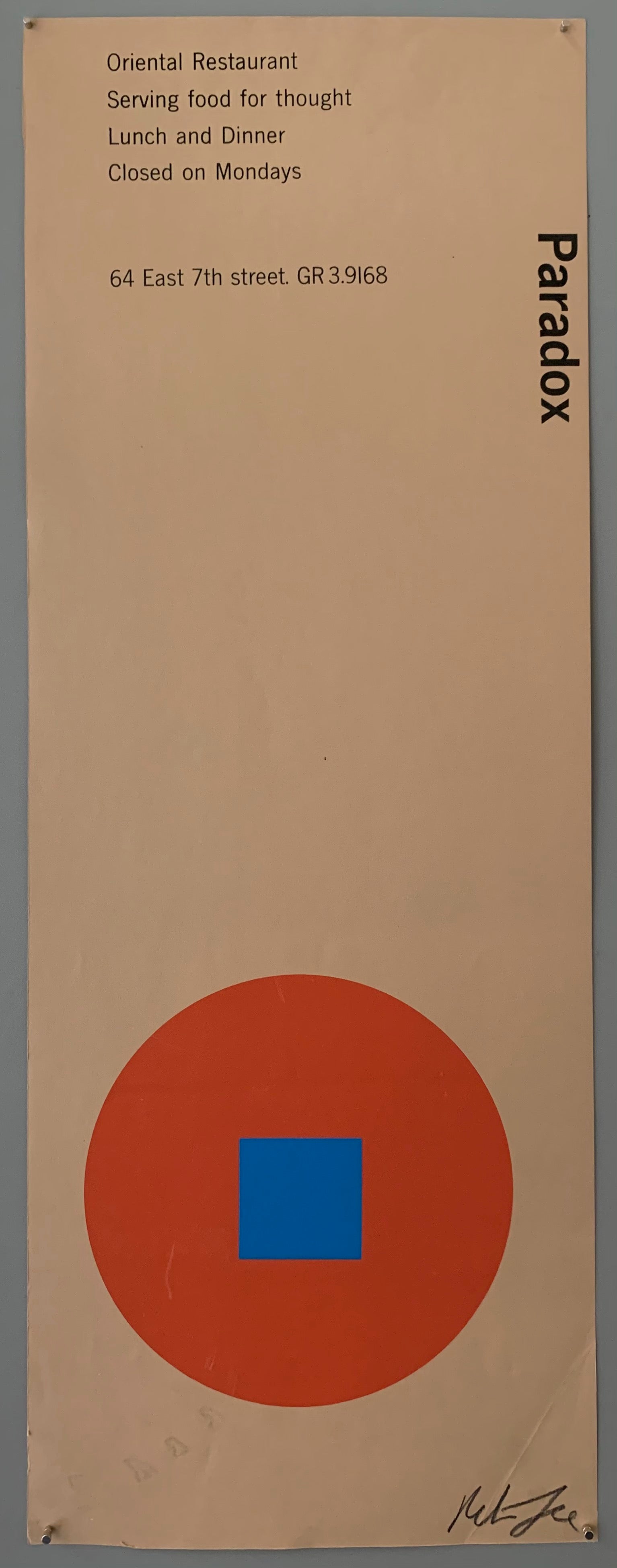 A red circle with a blue square on light brown paper.