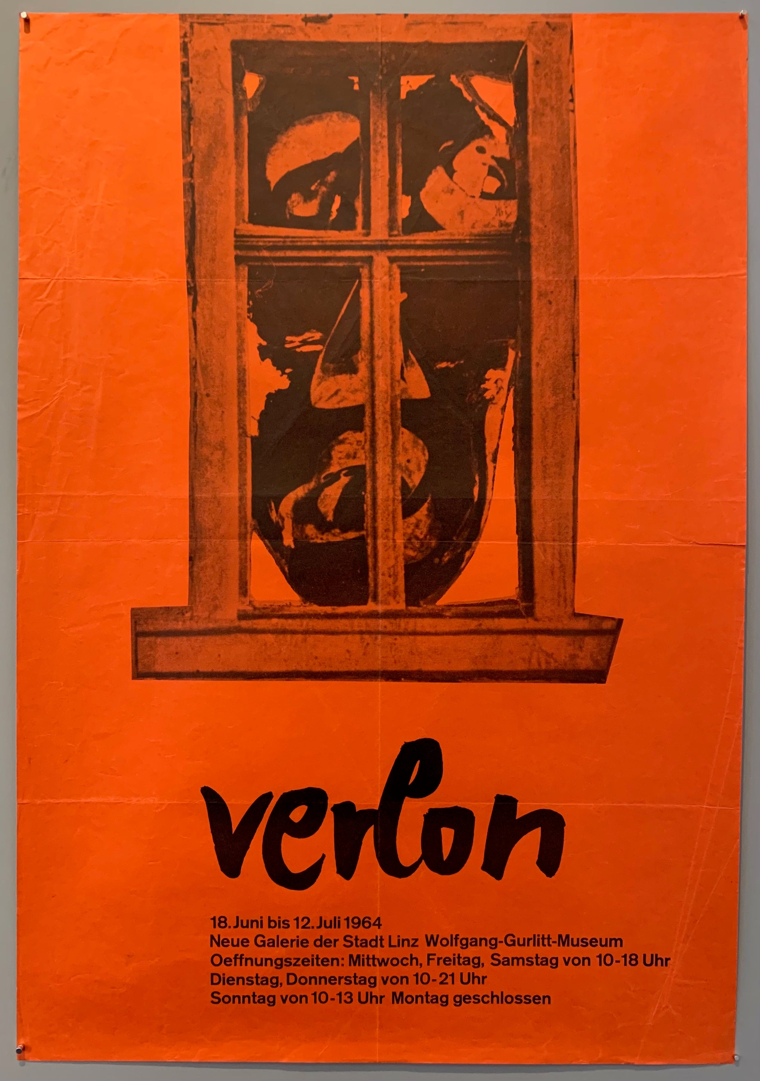 Abstract face behind a wooden window pane, poster is orange.